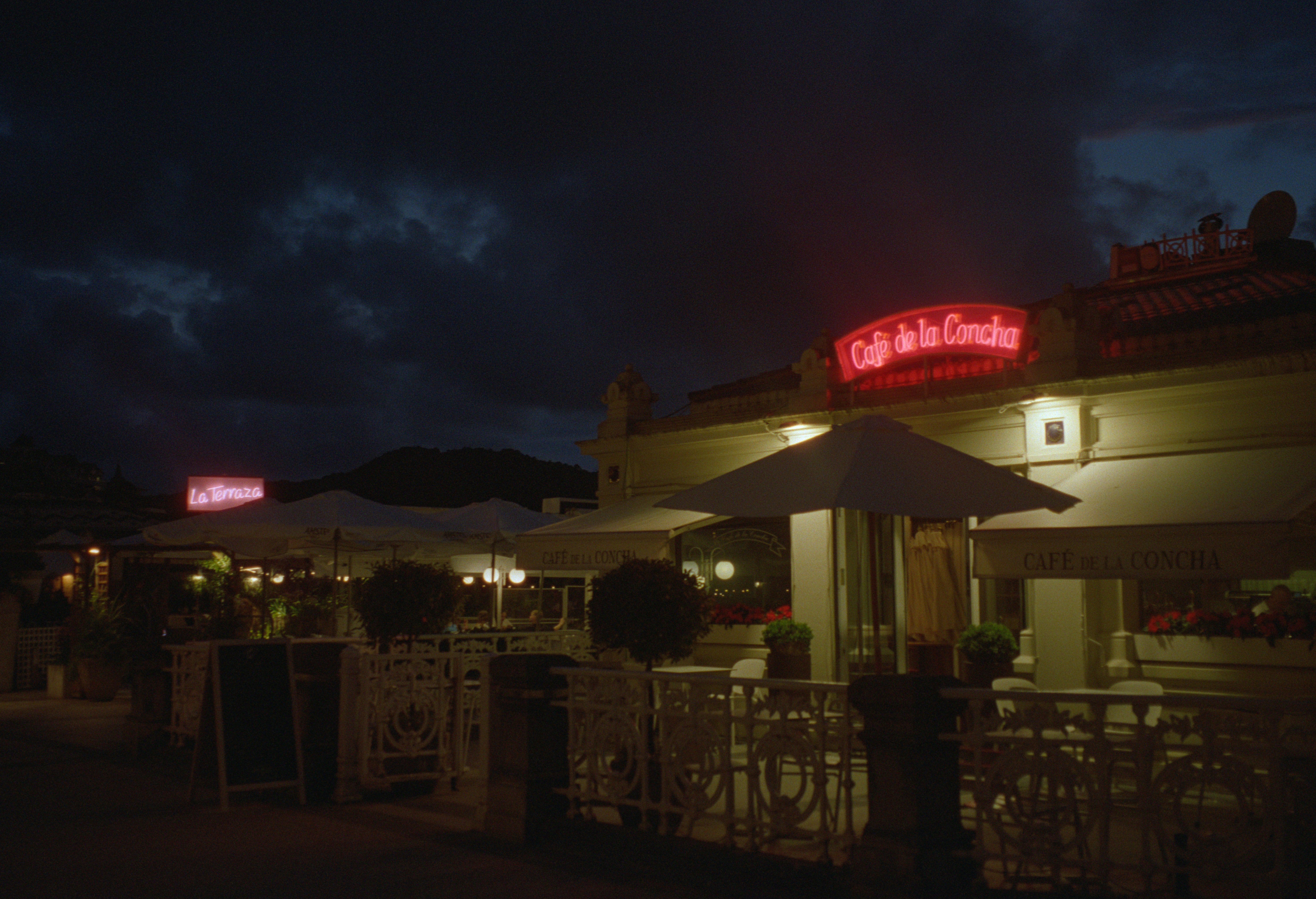 Cafe de la grotte with glowing neon sign at night.