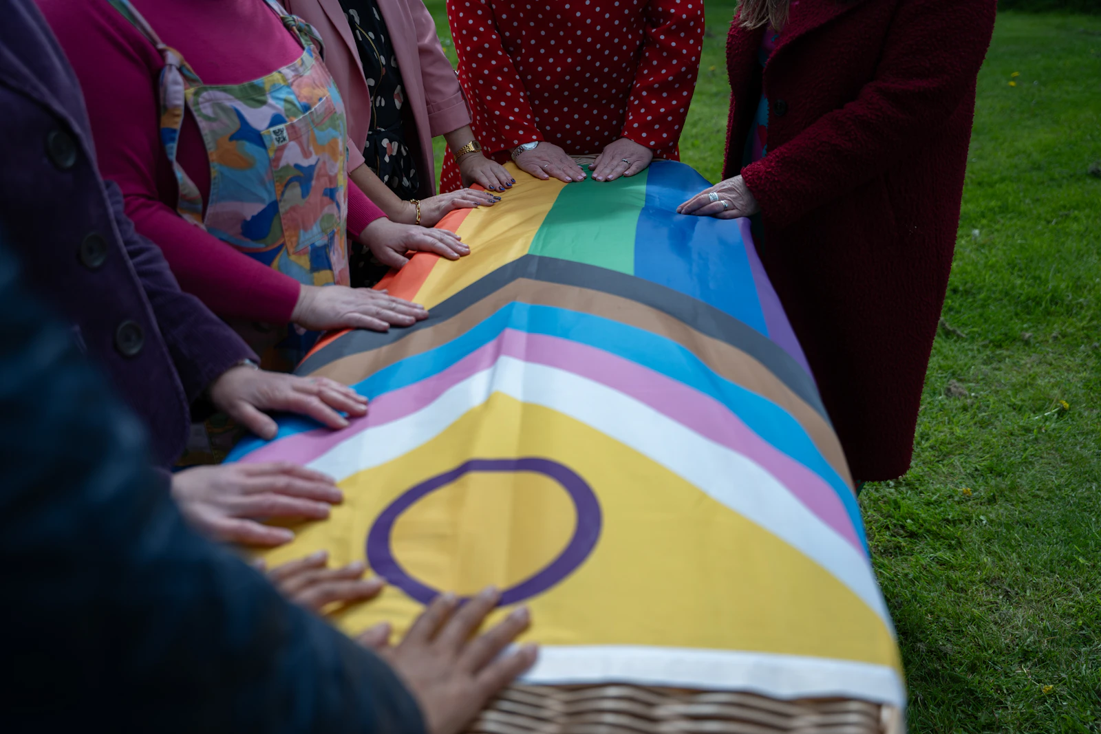 Hands holding a rainbow pride flag
