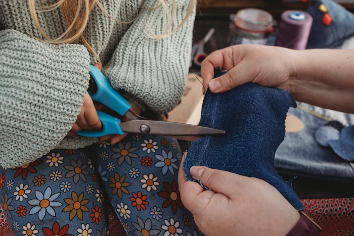 A child's hands cutting fabric with guidance