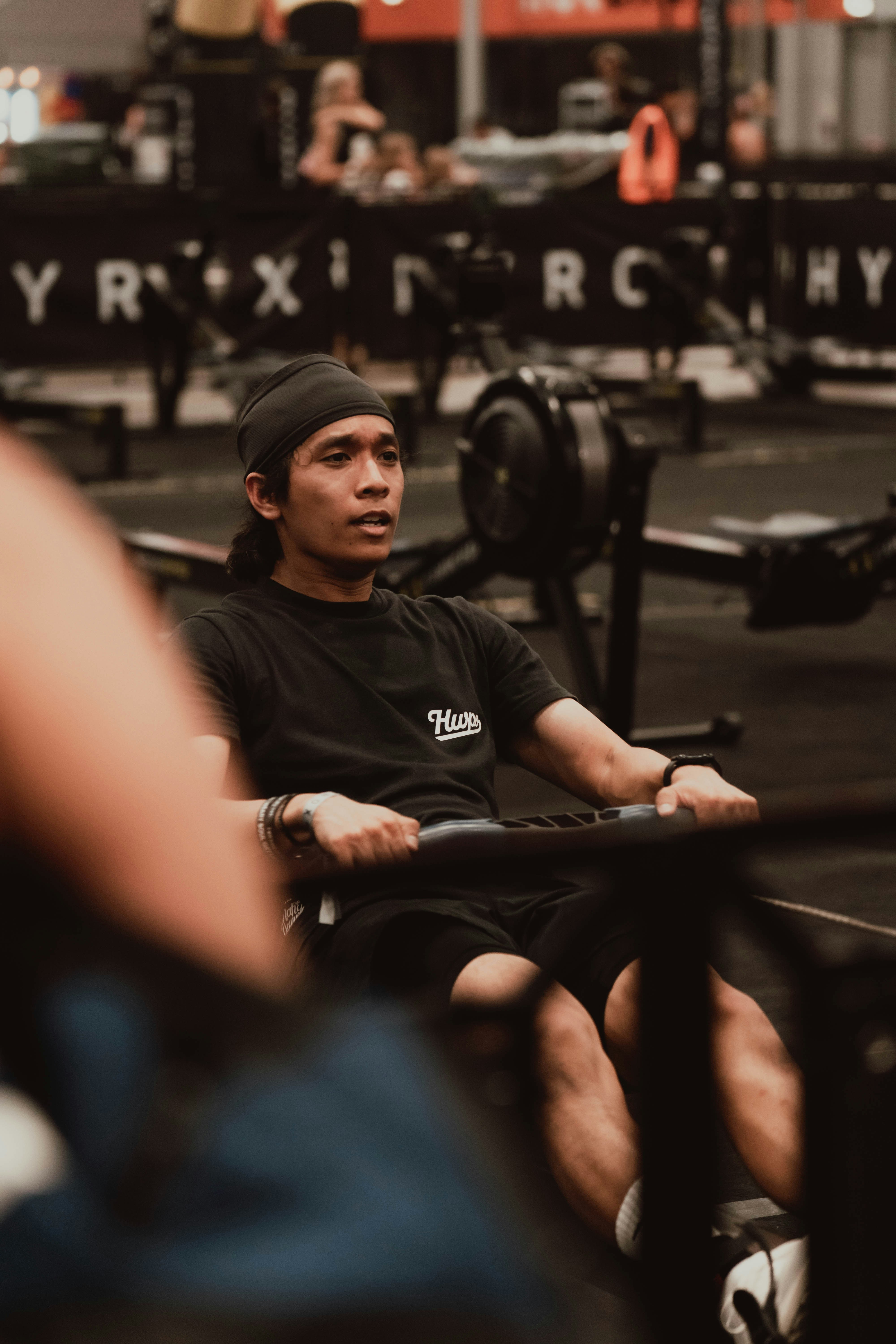 A man exercising on a rowing machine in a gym.