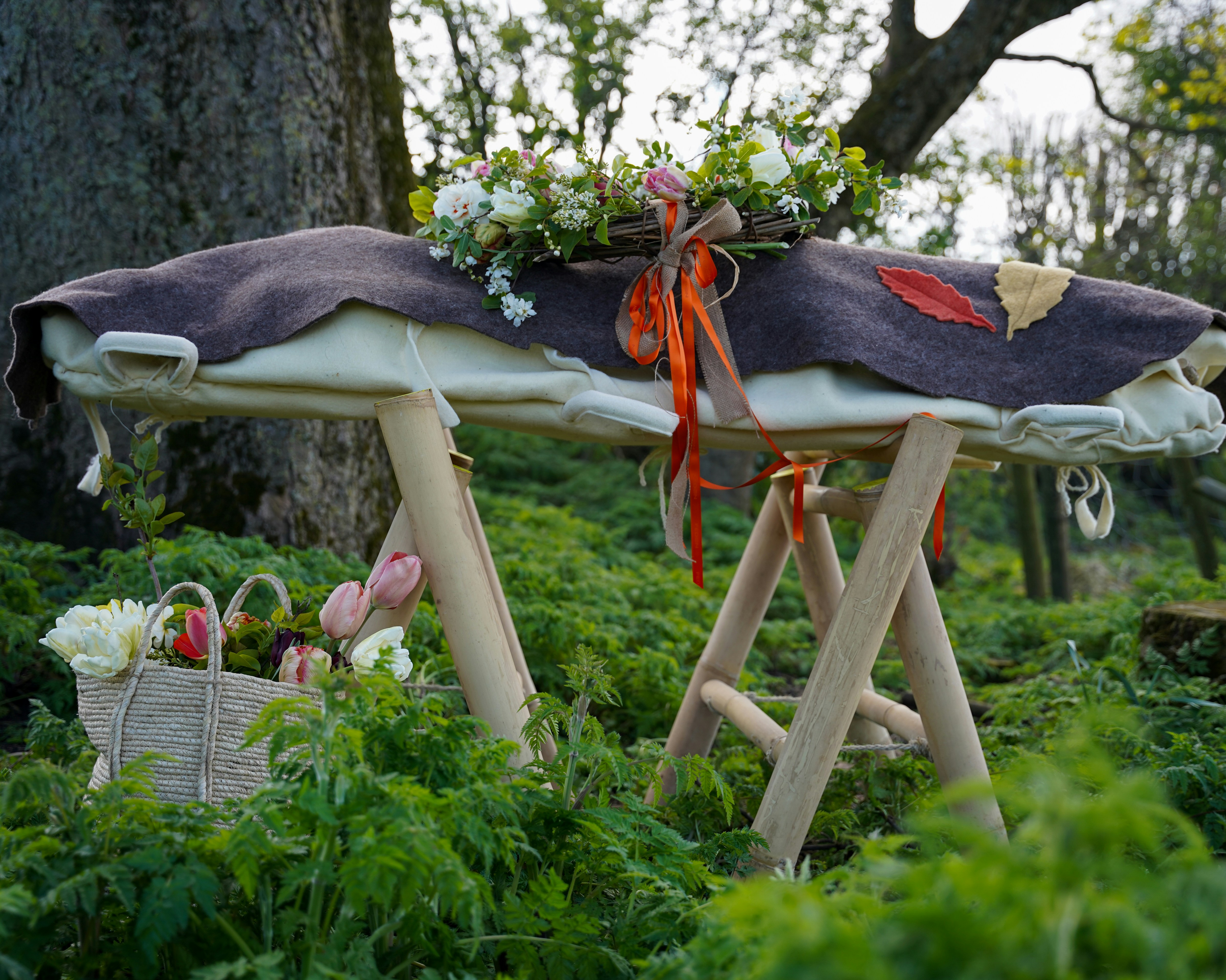 Outdoor wooden stand adorned with flowers and ribbons