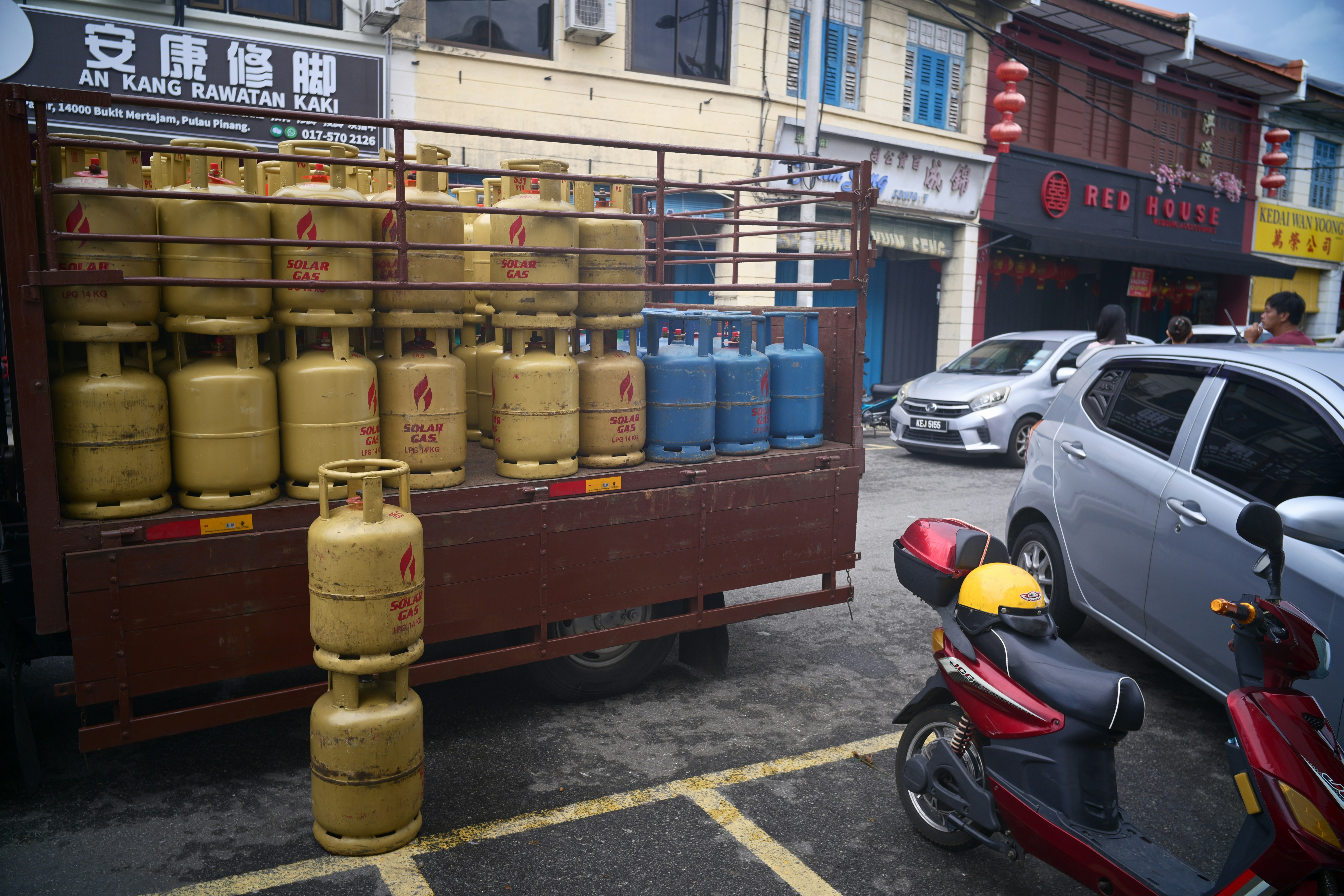Truk bermuatan tabung gas diparkir di jalan yang sibuk.
