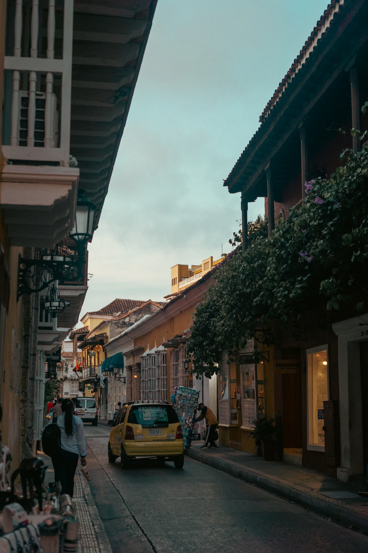 Cartagena Colombia historic centre at dusk with a yellow taxi on the colonial street and warm evening light on the Spanish colonial facades