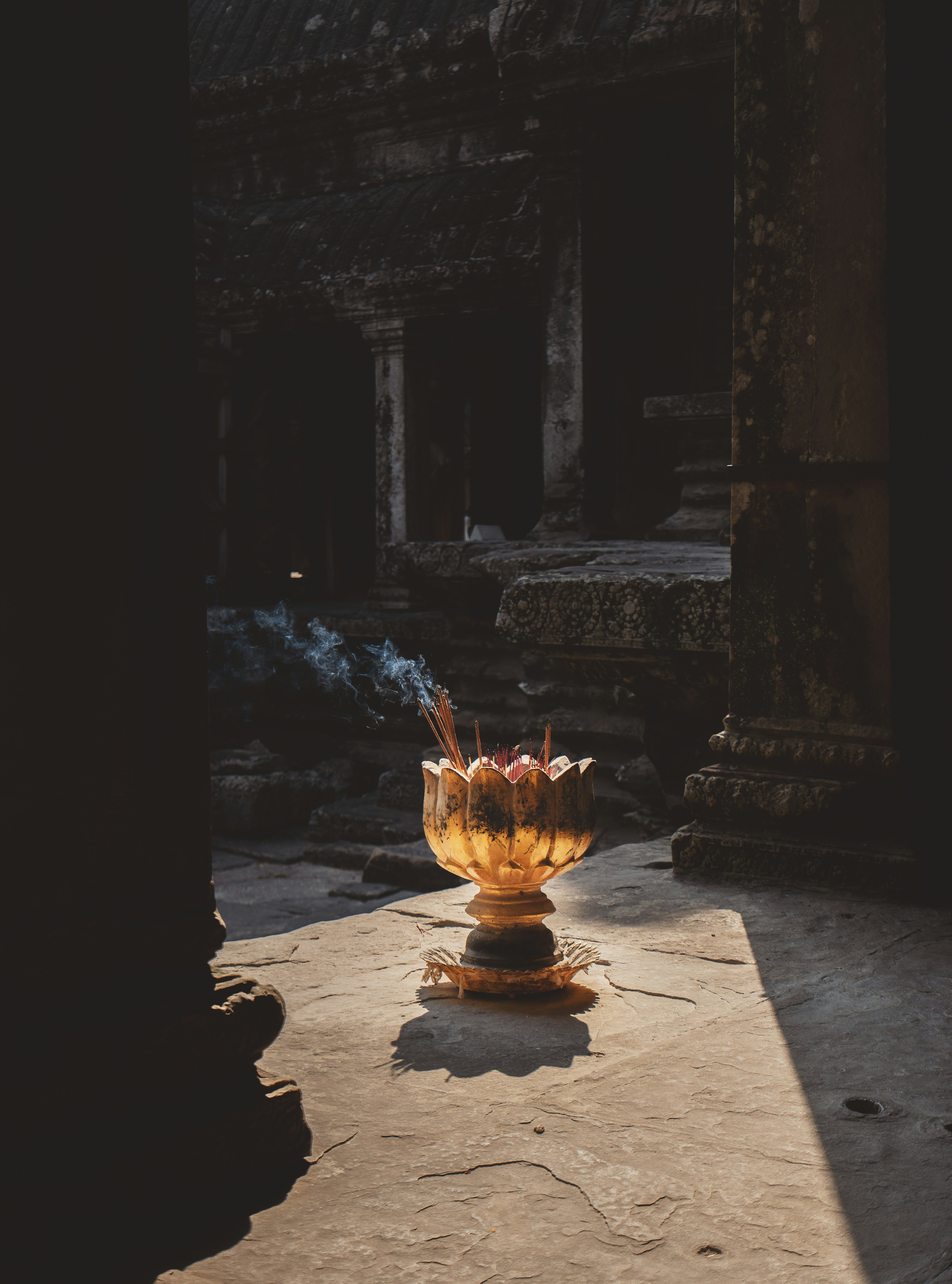 Golden incense burner with smoke in an ancient temple.