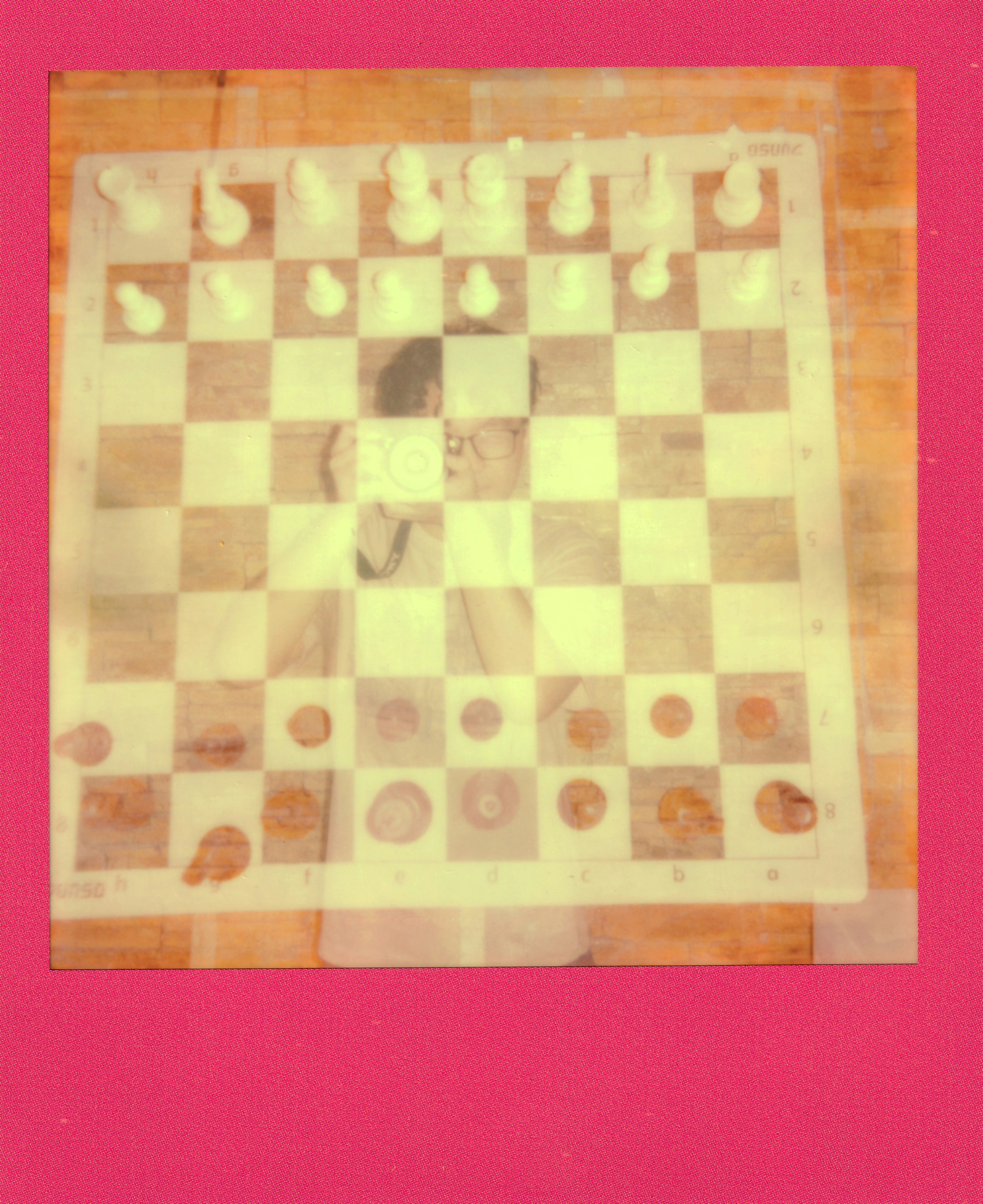 Faded chessboard with white pieces and tokens on wood.