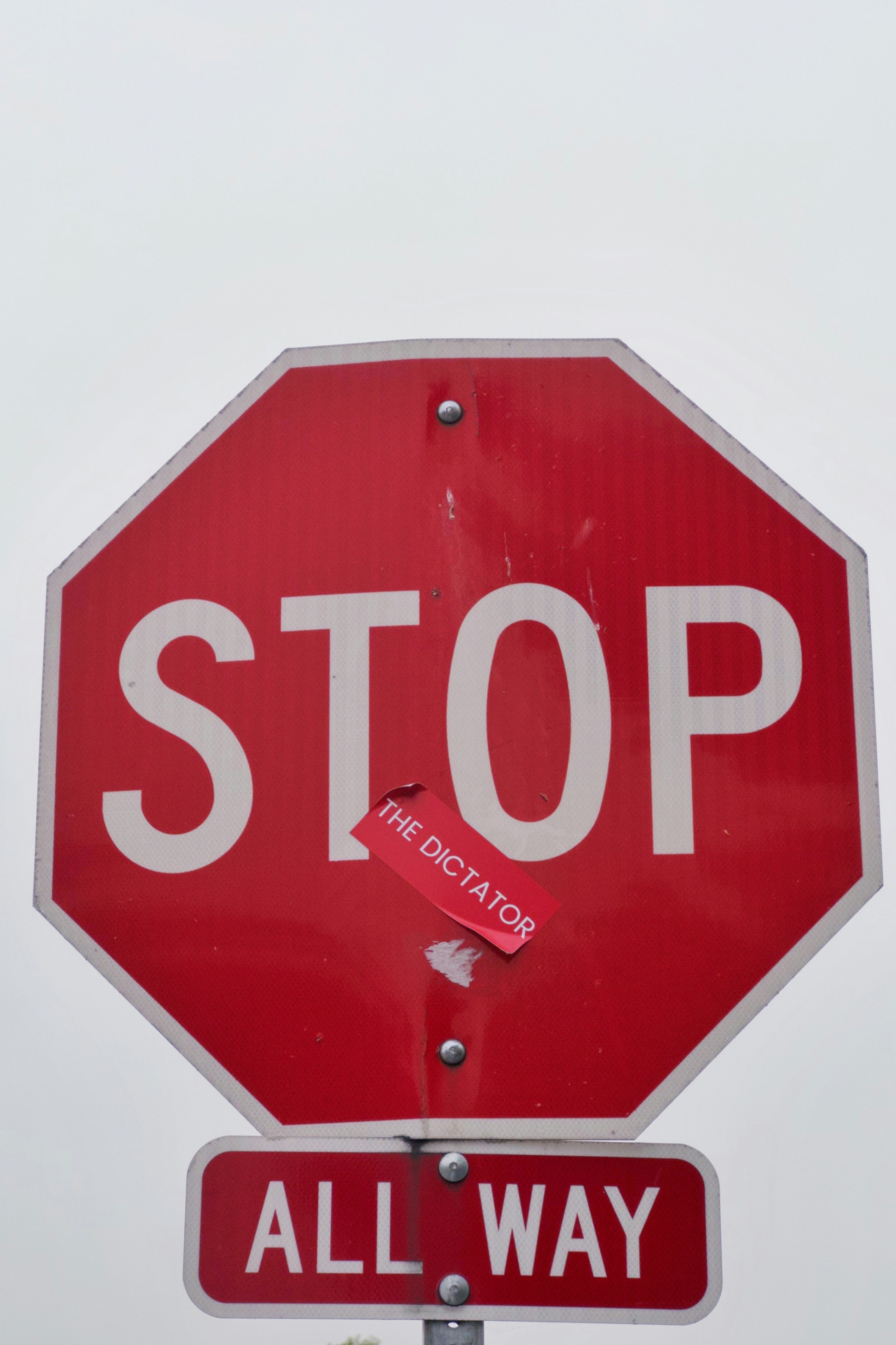 Rotes Stoppschild mit dem Aufkleber 'The Dictator', 'All way'.