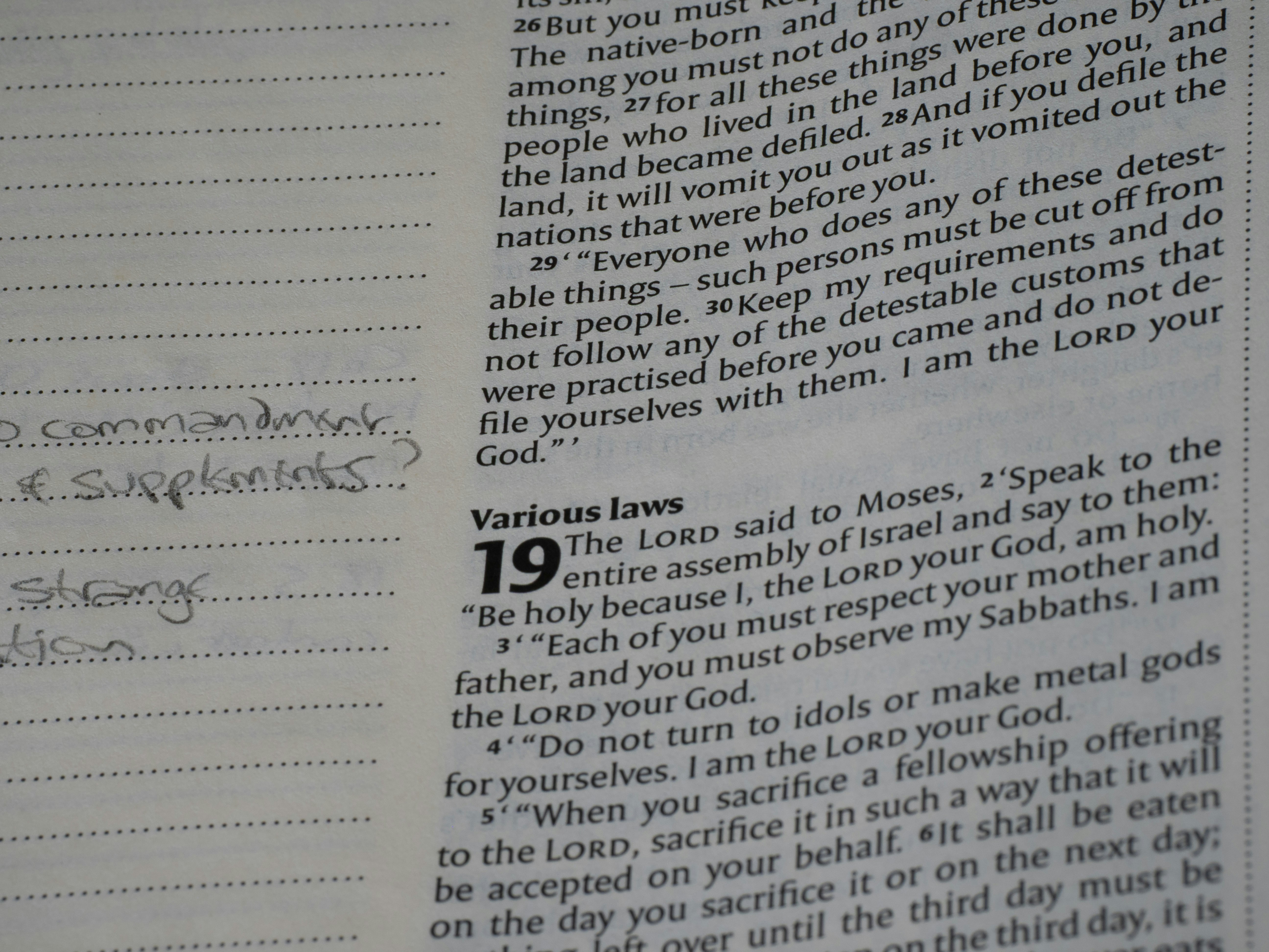 Open bible page showing text and handwritten notes.