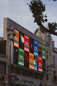 Harry styles concert posters displayed on a large digital billboard.