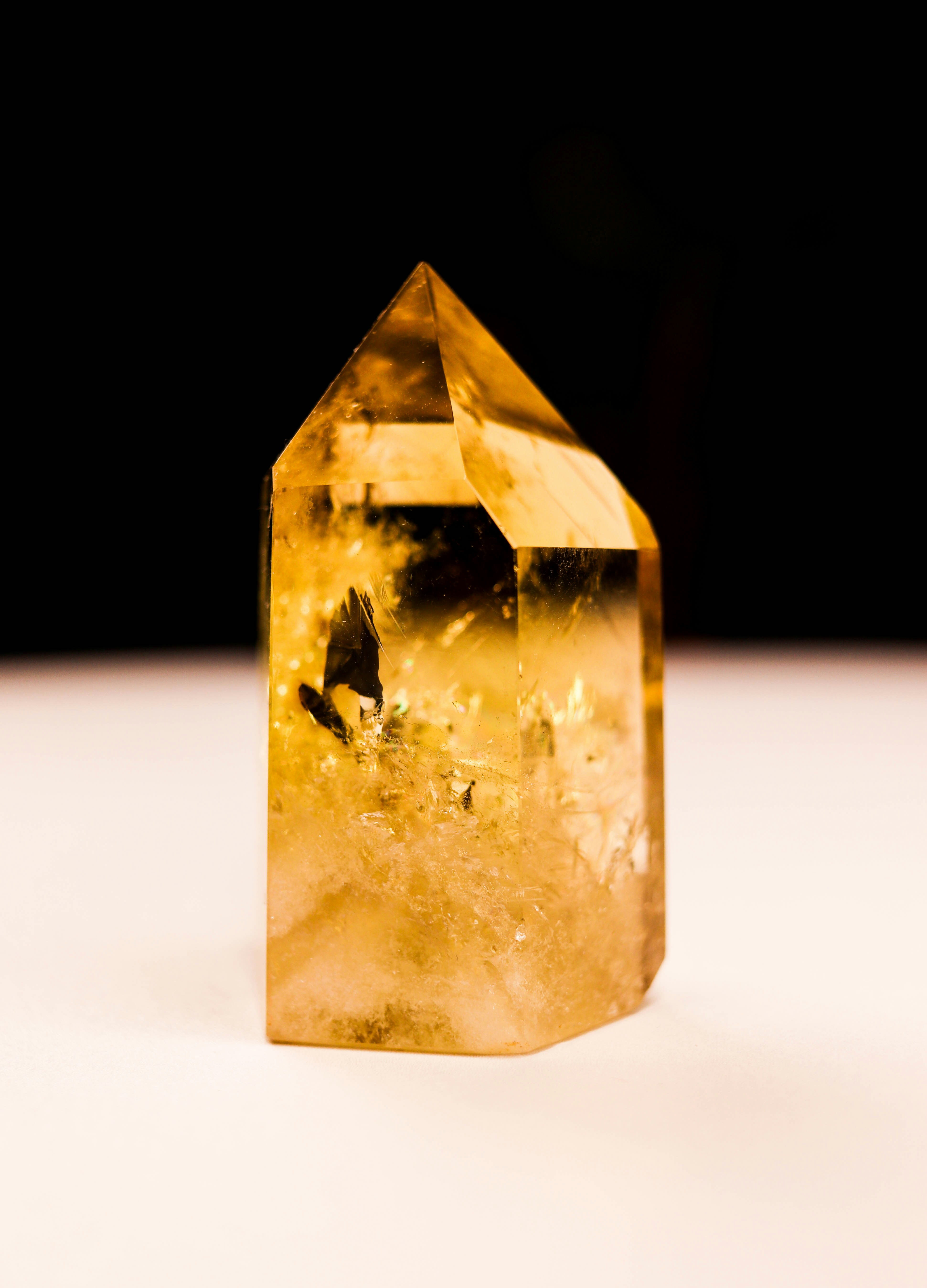 Une pointe cristalline jaune doré se dresse sur une surface claire