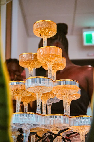 A pyramid of champagne glasses filled with sparkling golden liquid.