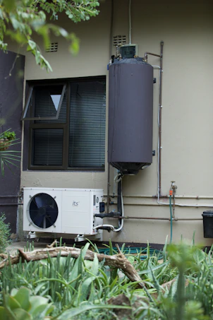 Residential water heater and air conditioner on an exterior wall.