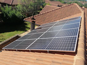 Solar panels on a red tile roof.