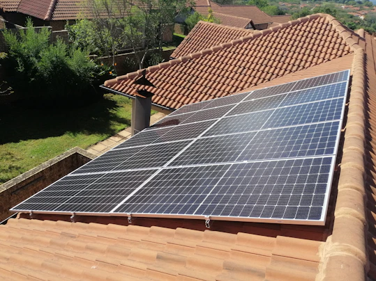 Solar panels on a red tile roof.