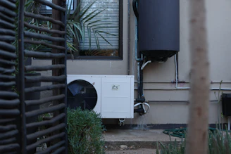 White outdoor air conditioning unit on a building wall