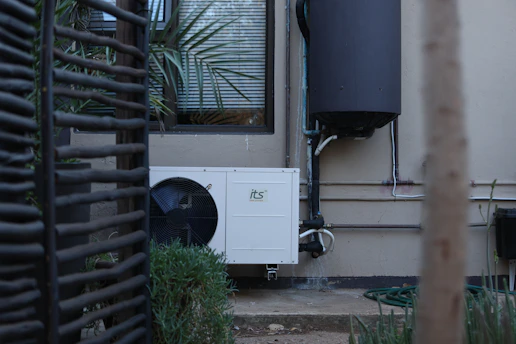 White outdoor air conditioning unit on a building wall
