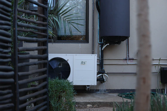 White outdoor air conditioning unit on a building wall