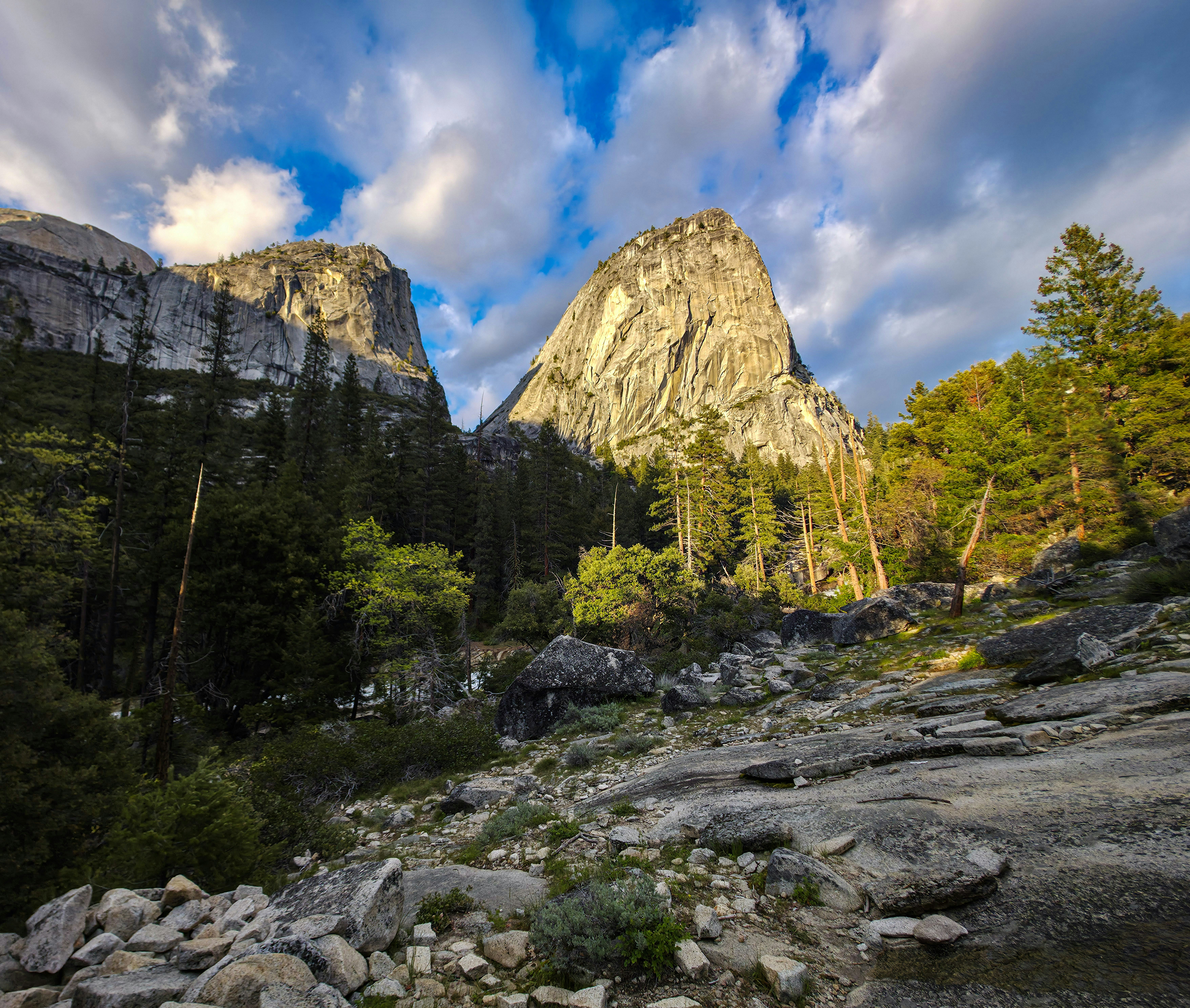 Majestic mountains and green forest under a cloudy sky.