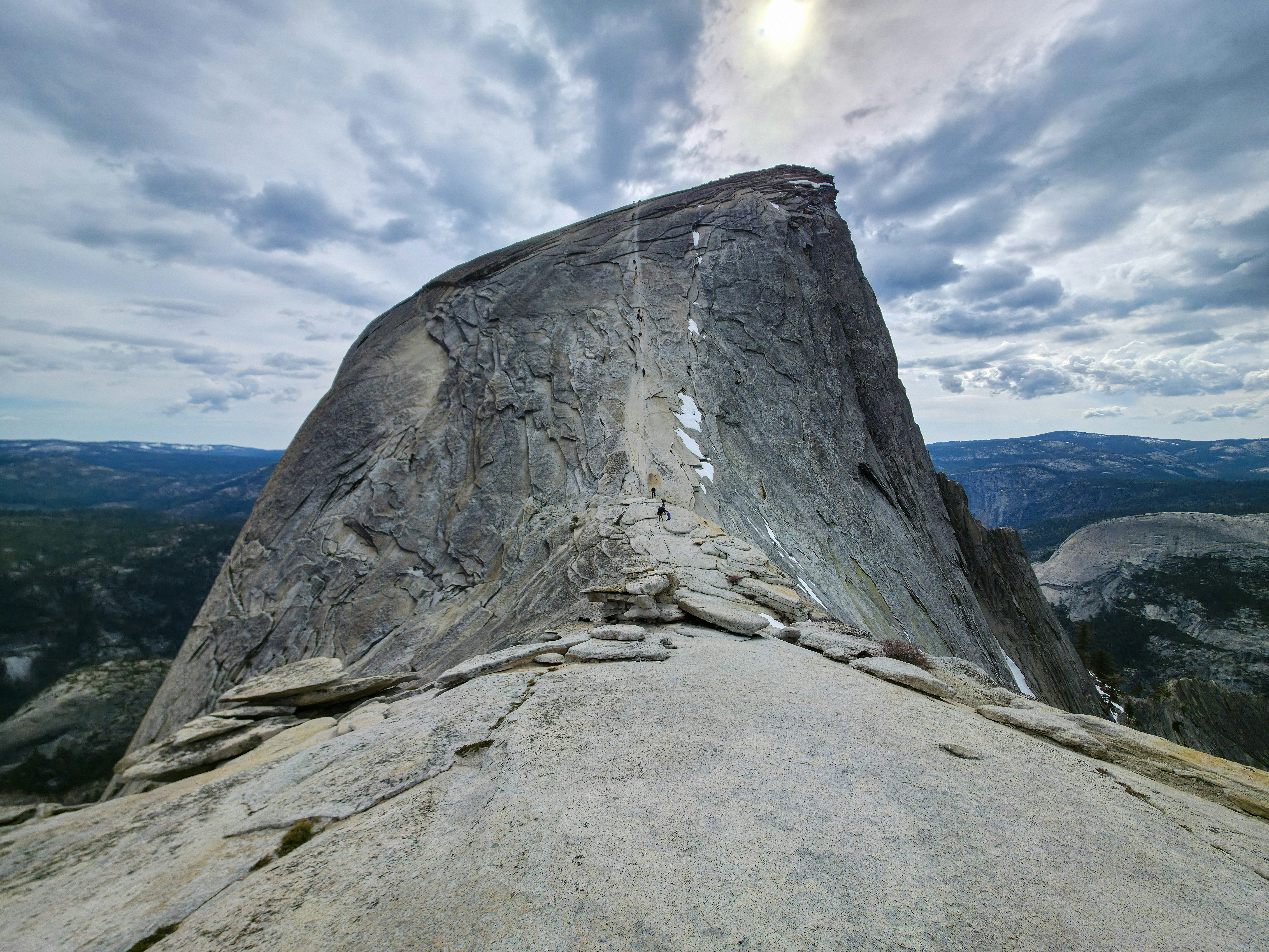 Majestic half dome granite peak under a dramatic sky.