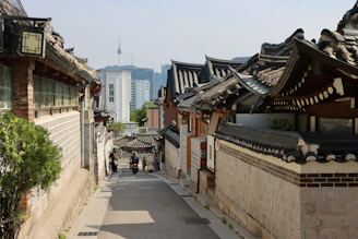 Rua estreita em vila hanok tradicional na Coreia do Sul, com casas de telhado curvo