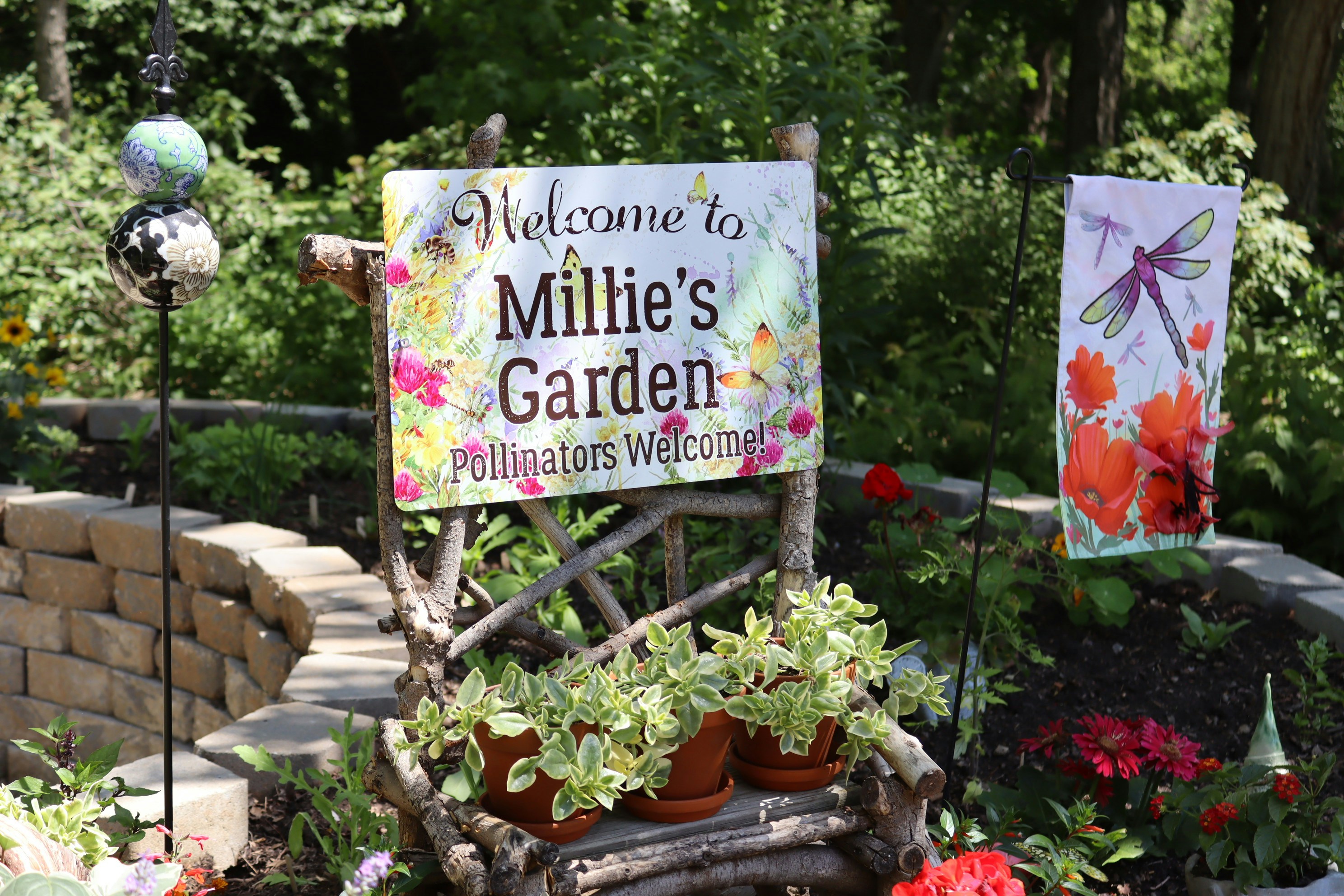 Millie's garden sign, potted plants, and a dragonfly banner.