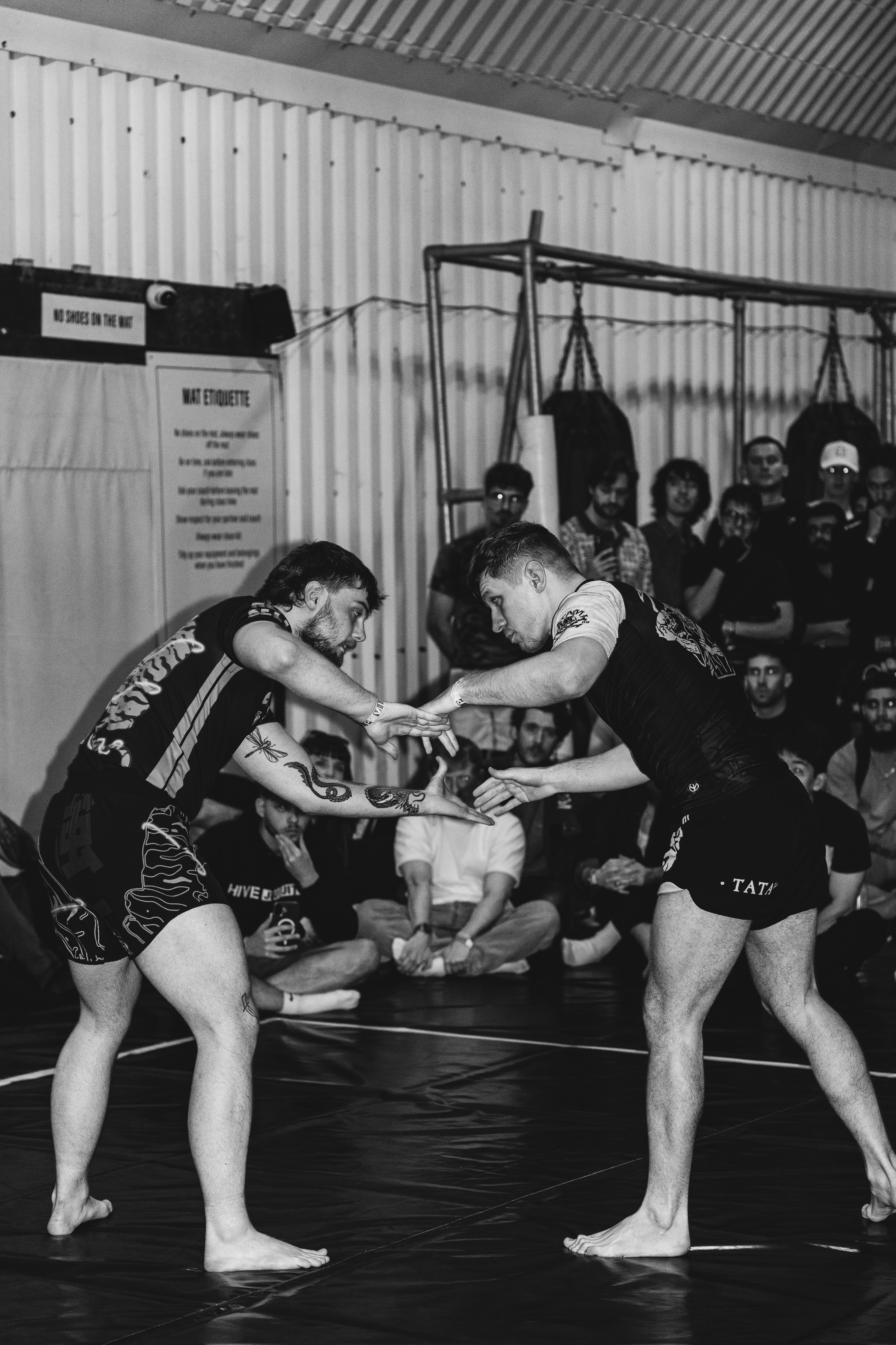 Two men engage in a grappling match on a mat