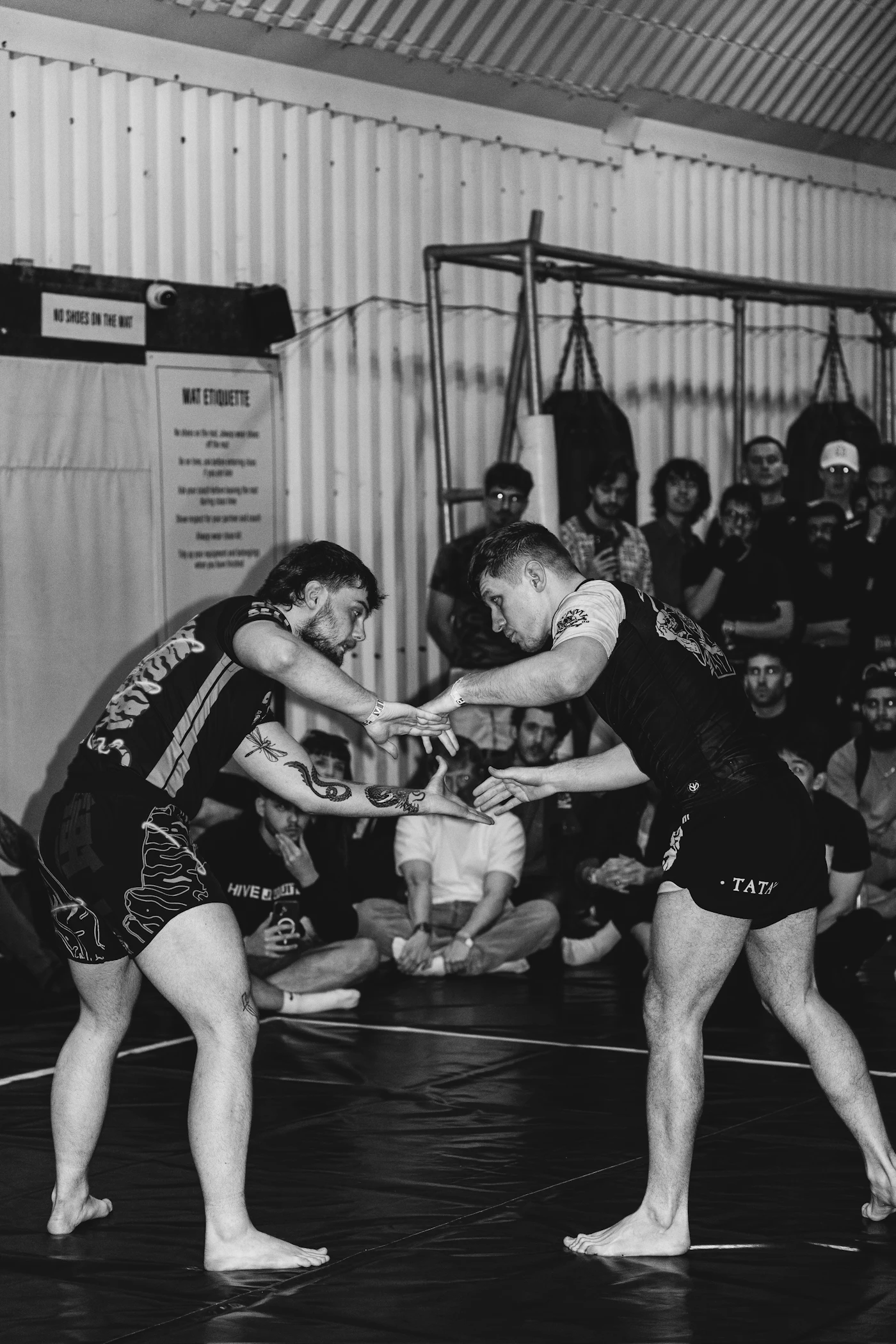 Two men engaged in a grappling exchange on a mat