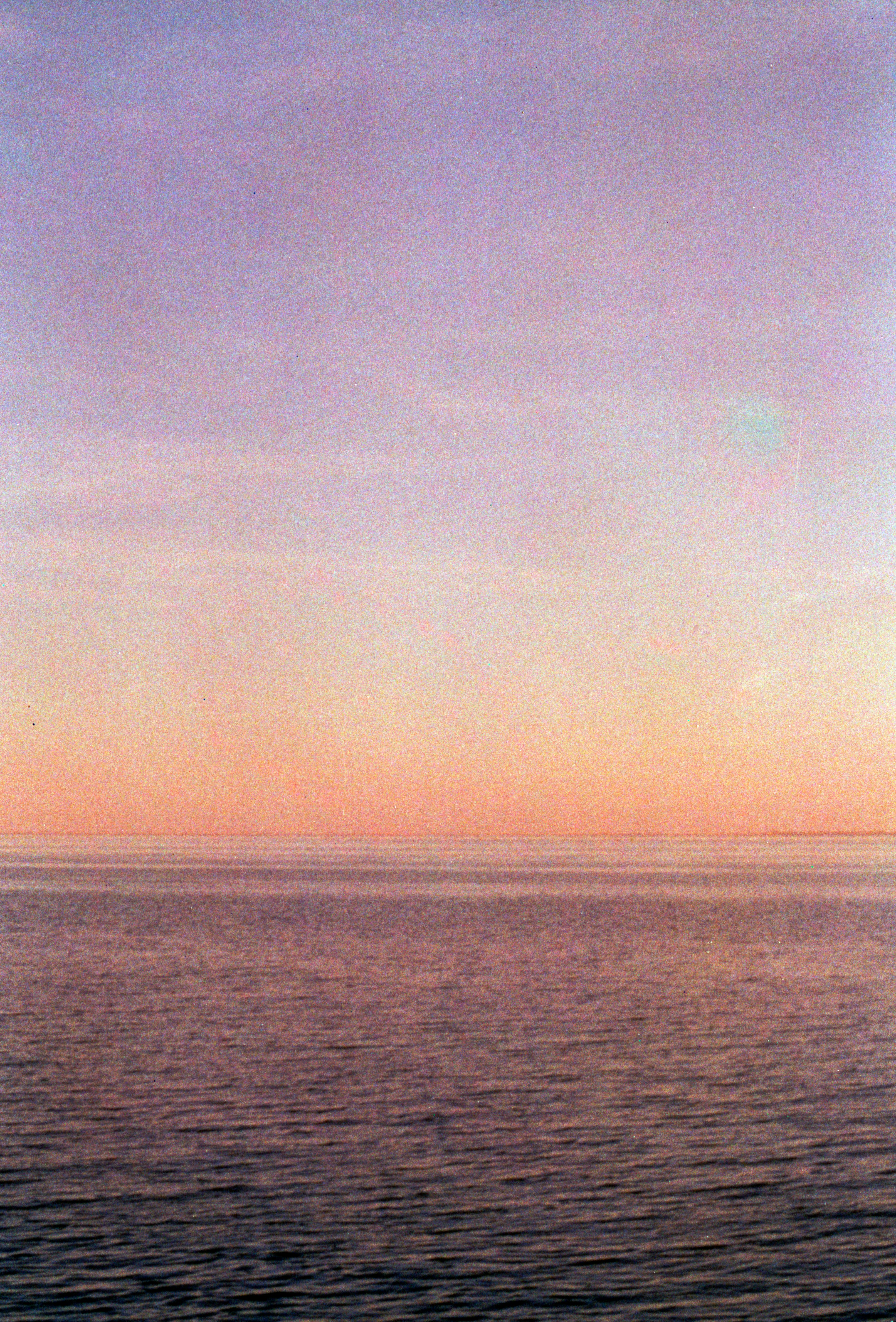 美しいグラデーションの夕焼け空の下、穏やかな海。