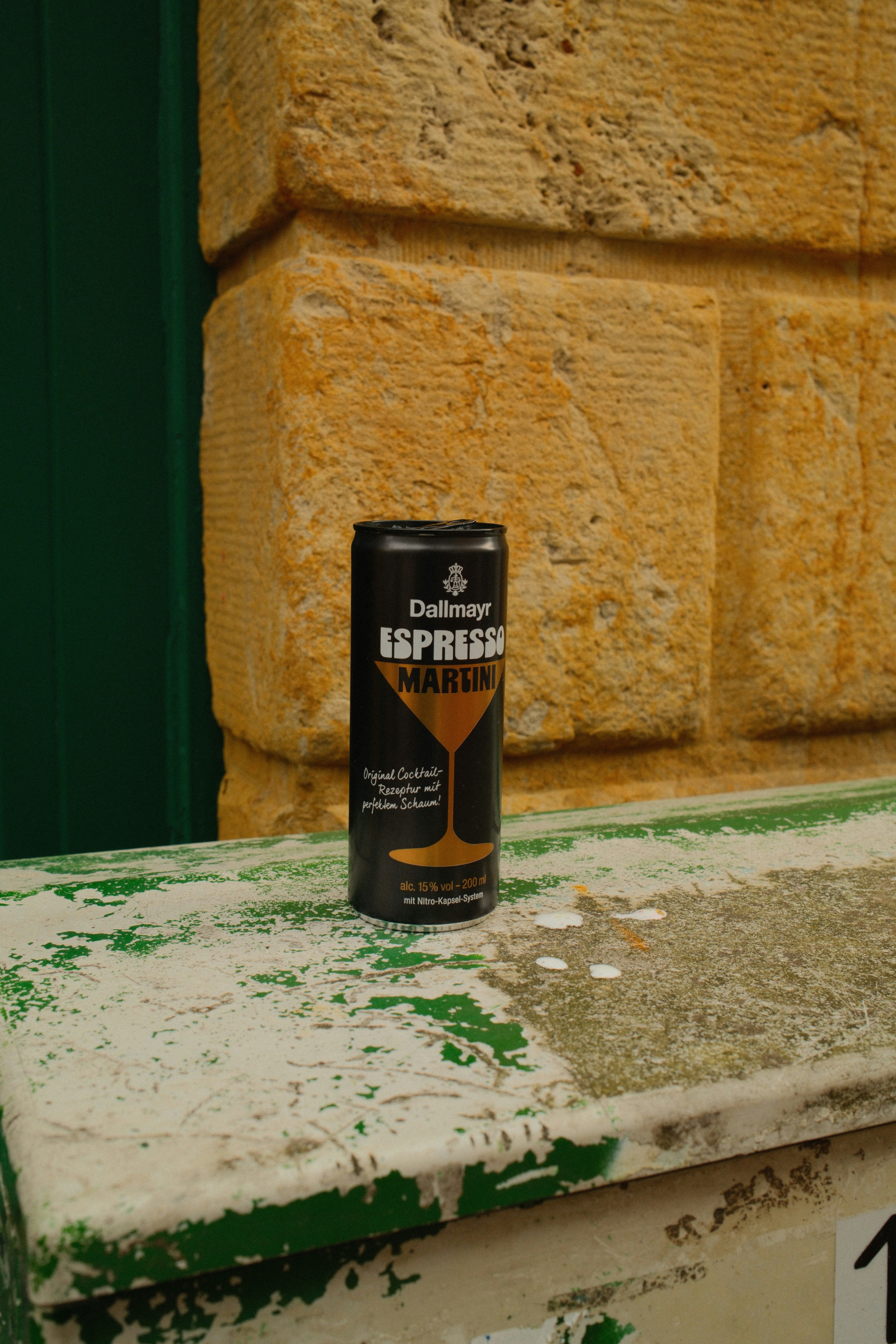 Kaleng martini espresso dallmayr hitam di permukaan lapuk.