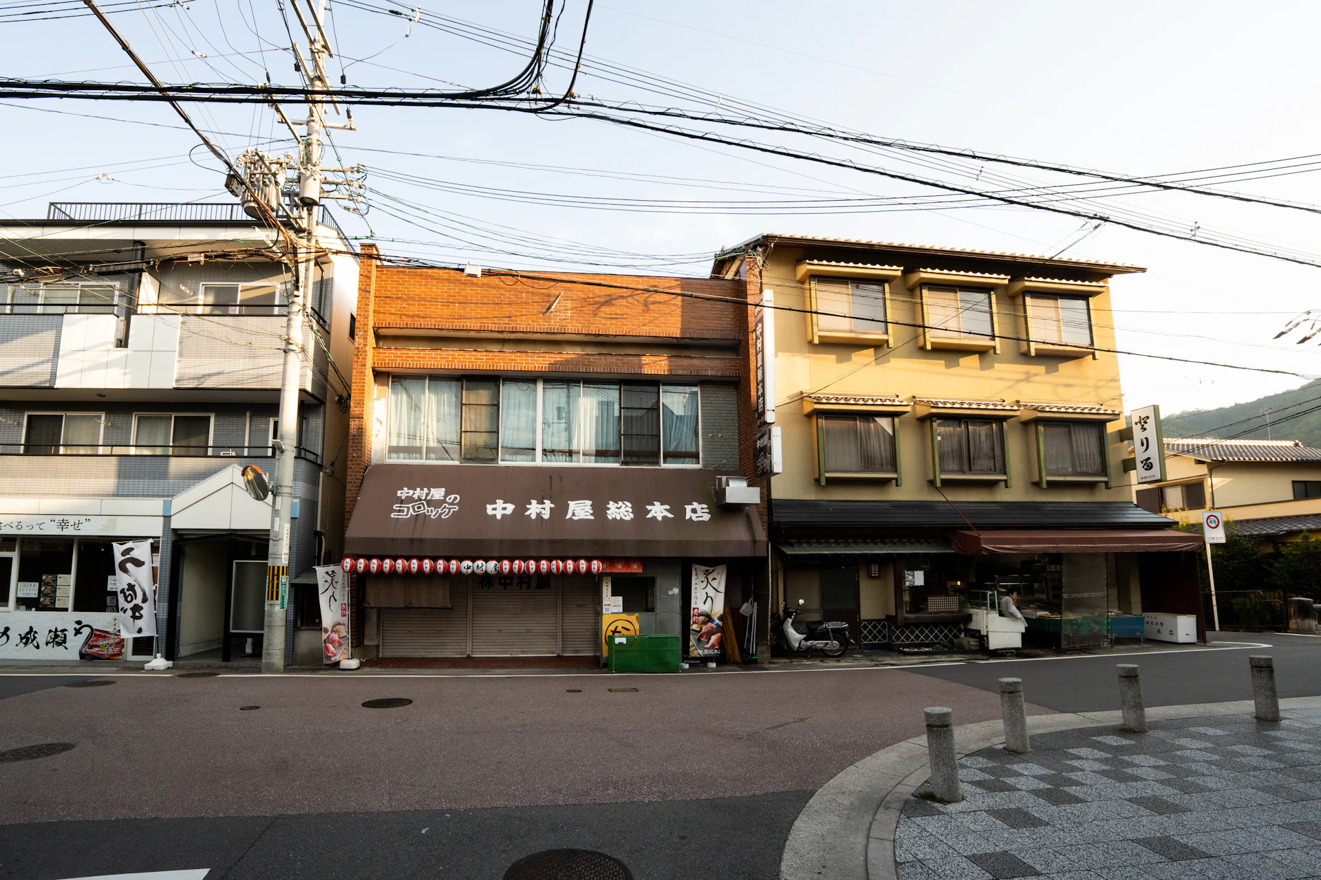 Old japanese street with traditional buildings and power lines.