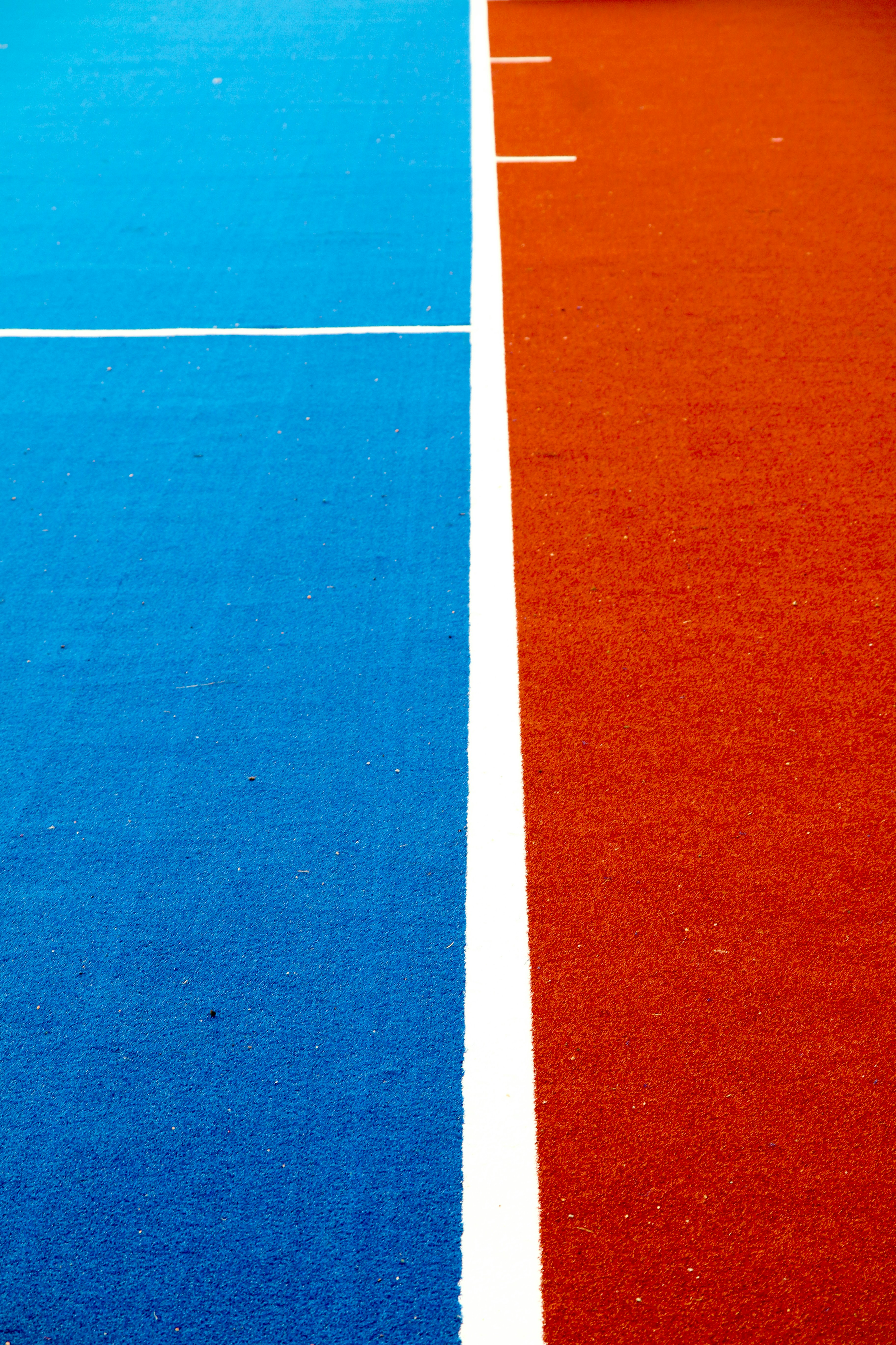 A blue and red court divided by a white line.