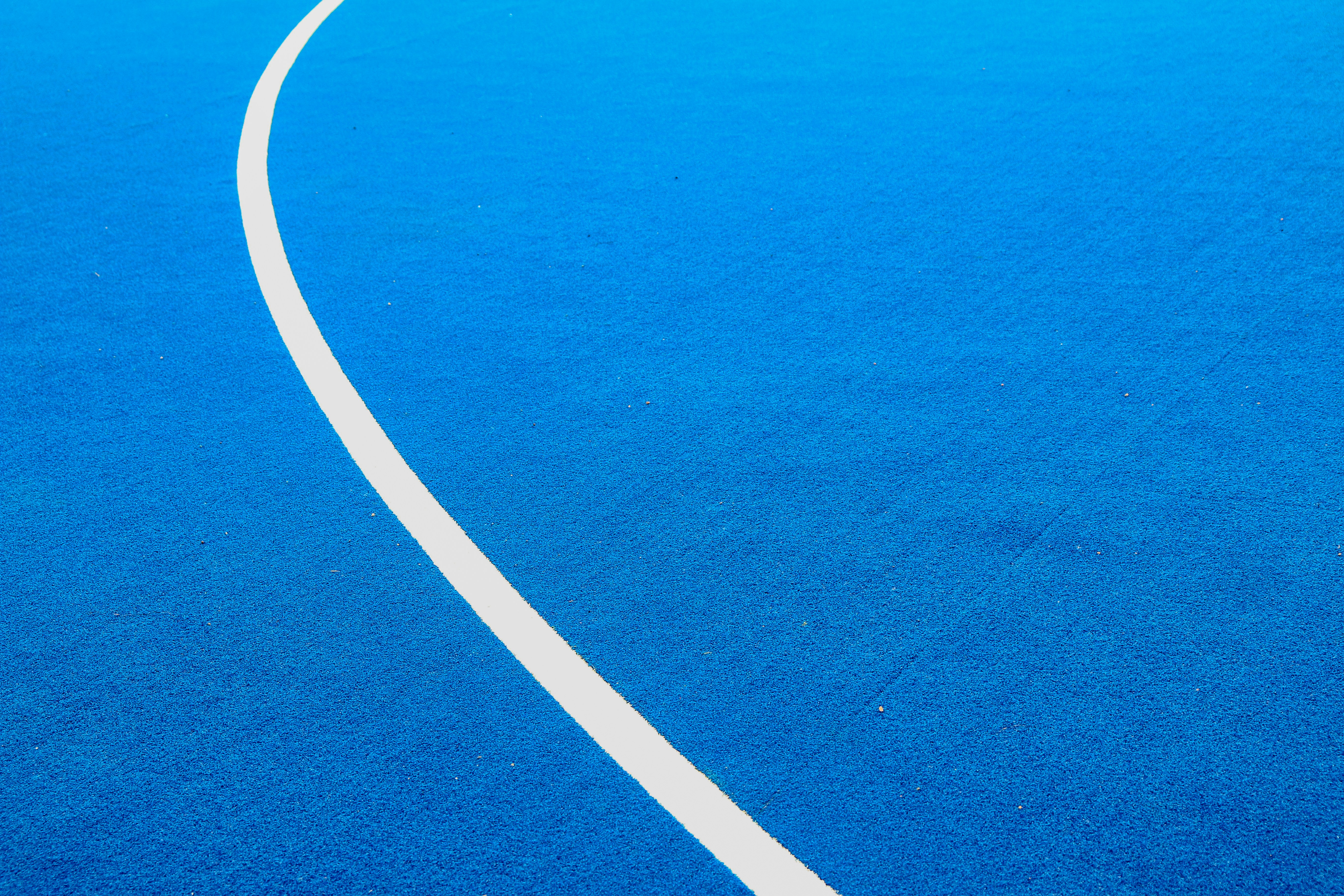 A solid blue background with a single white curved line.