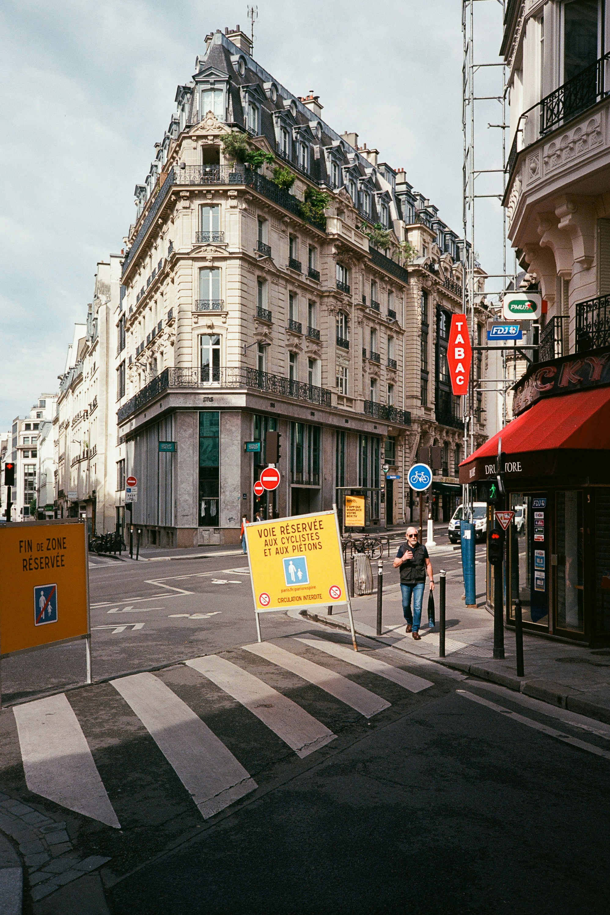 Historisches Pariser Gebäude an einer Straßenkreuzung mit Schildern.