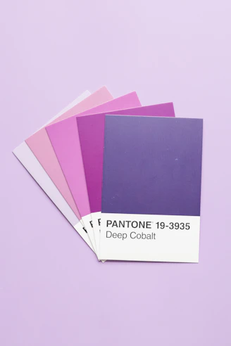 Fanned pantone color swatches displaying shades of pink and purple