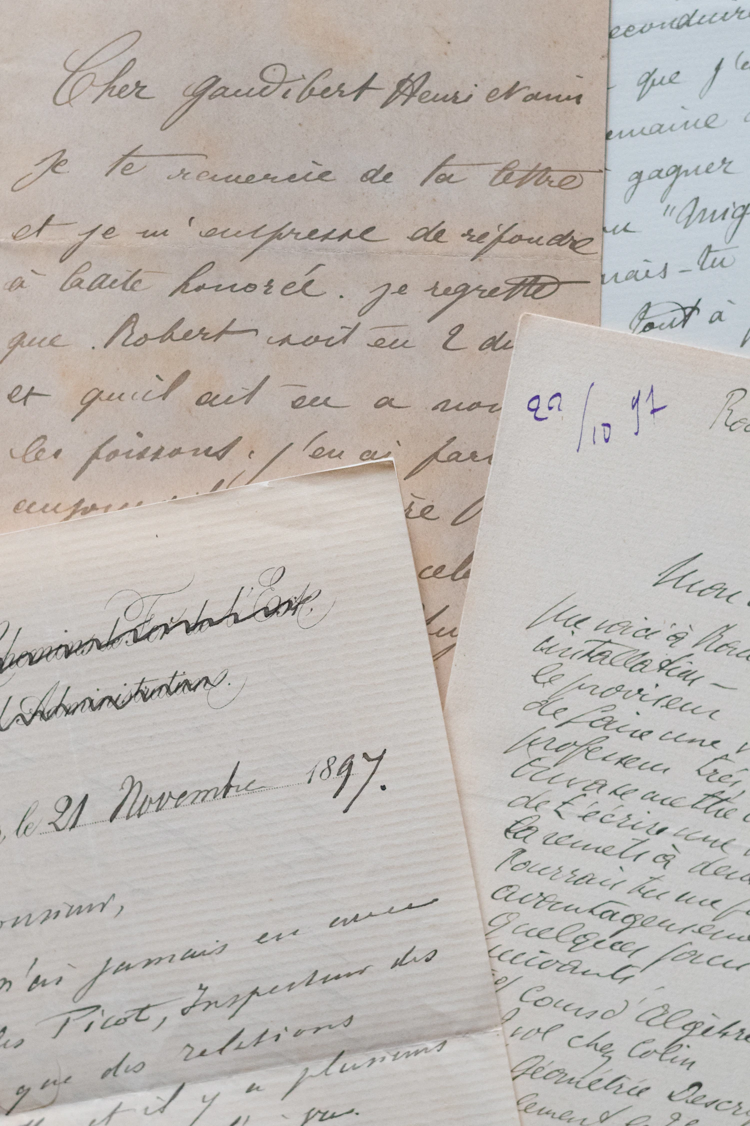 A stack of handwritten letters in brown ink laid on a pale surface