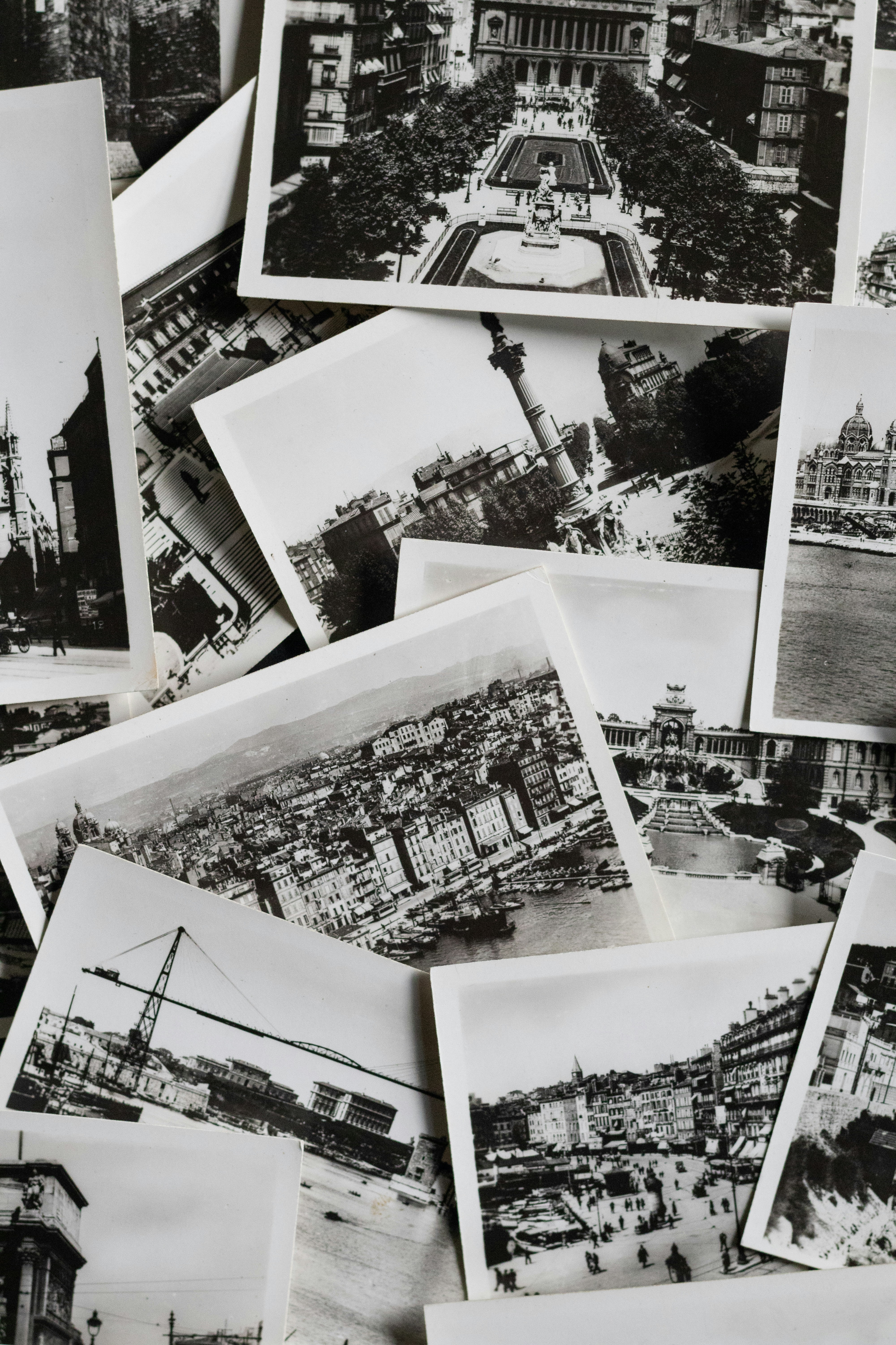 A pile of vintage black and white postcards showing cityscapes.