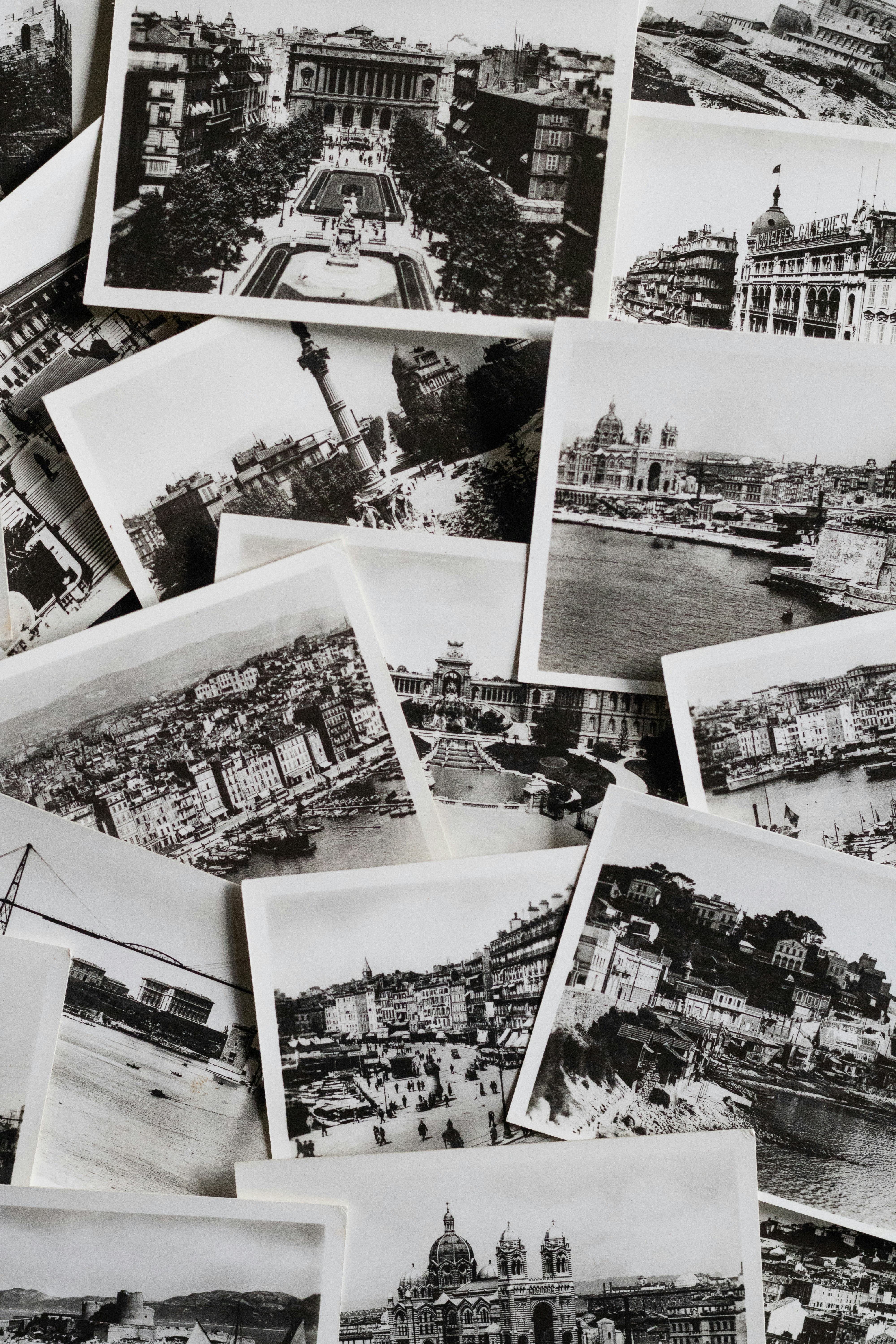 A pile of black and white vintage postcards showing cityscapes.