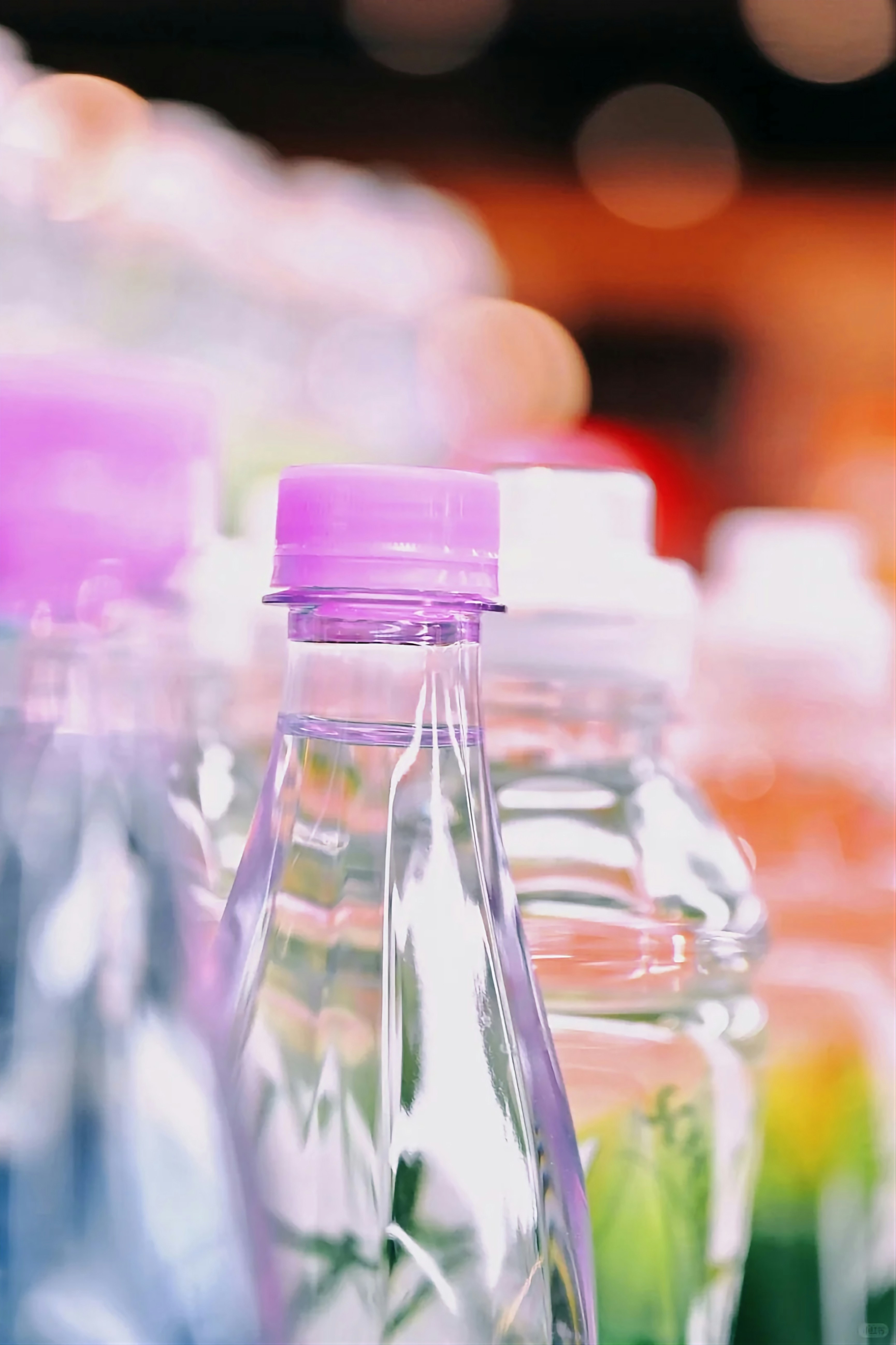 Clear plastic bottle with a vibrant purple cap.