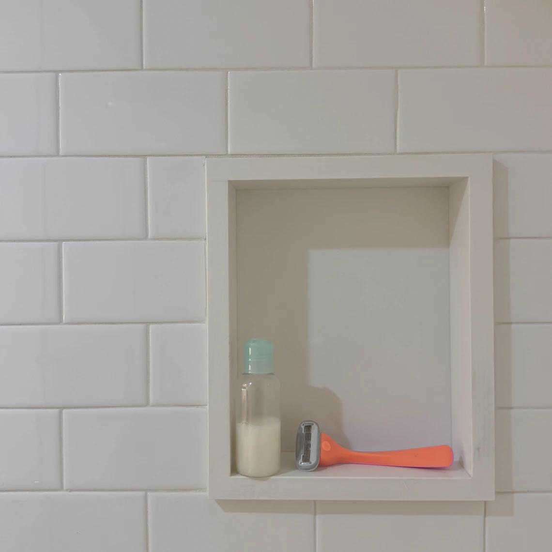 Shower shelf with personal care bottle, razor, bathing, and grooming essentials