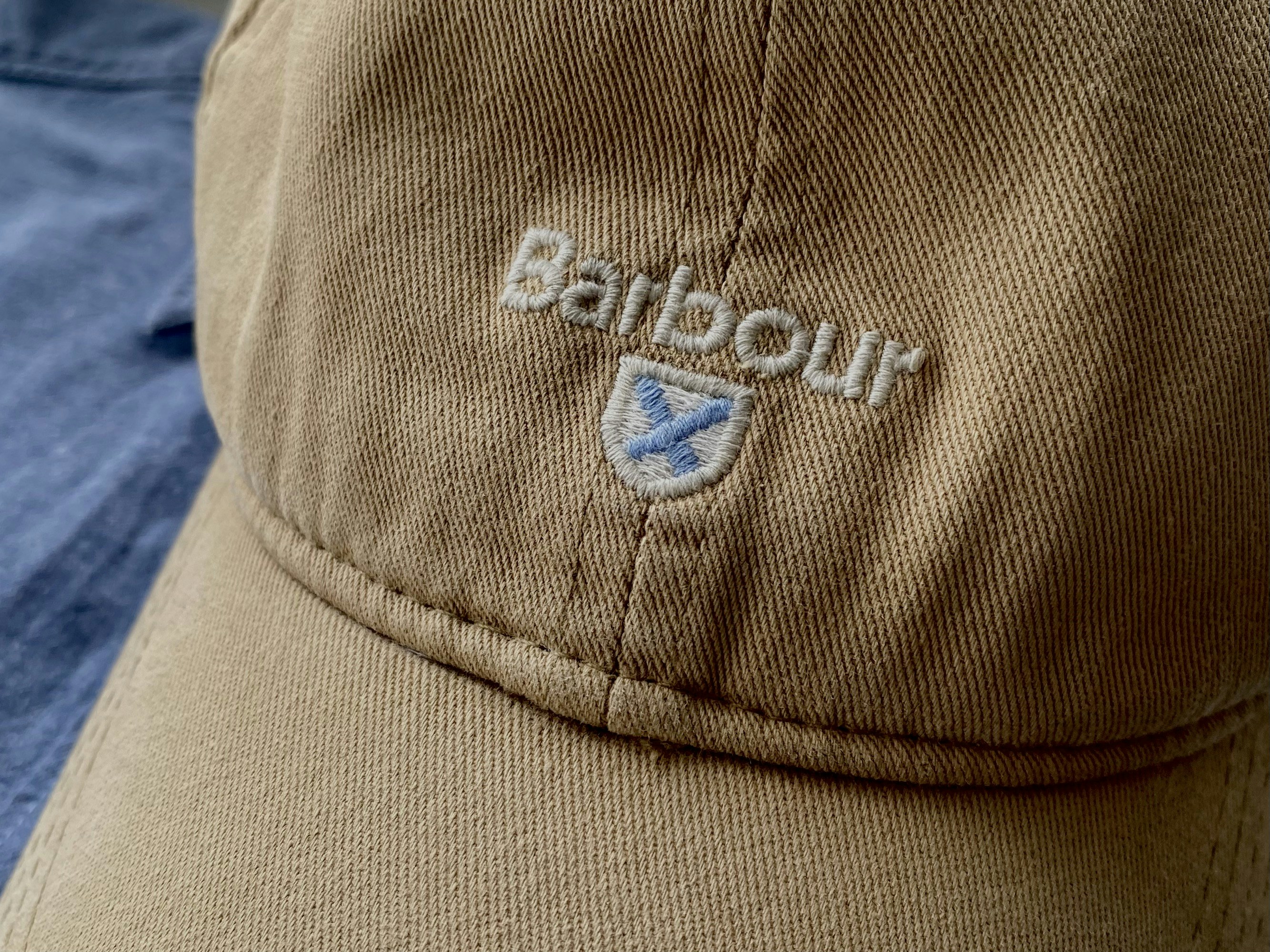 A beige barbour baseball cap with an embroidered logo.