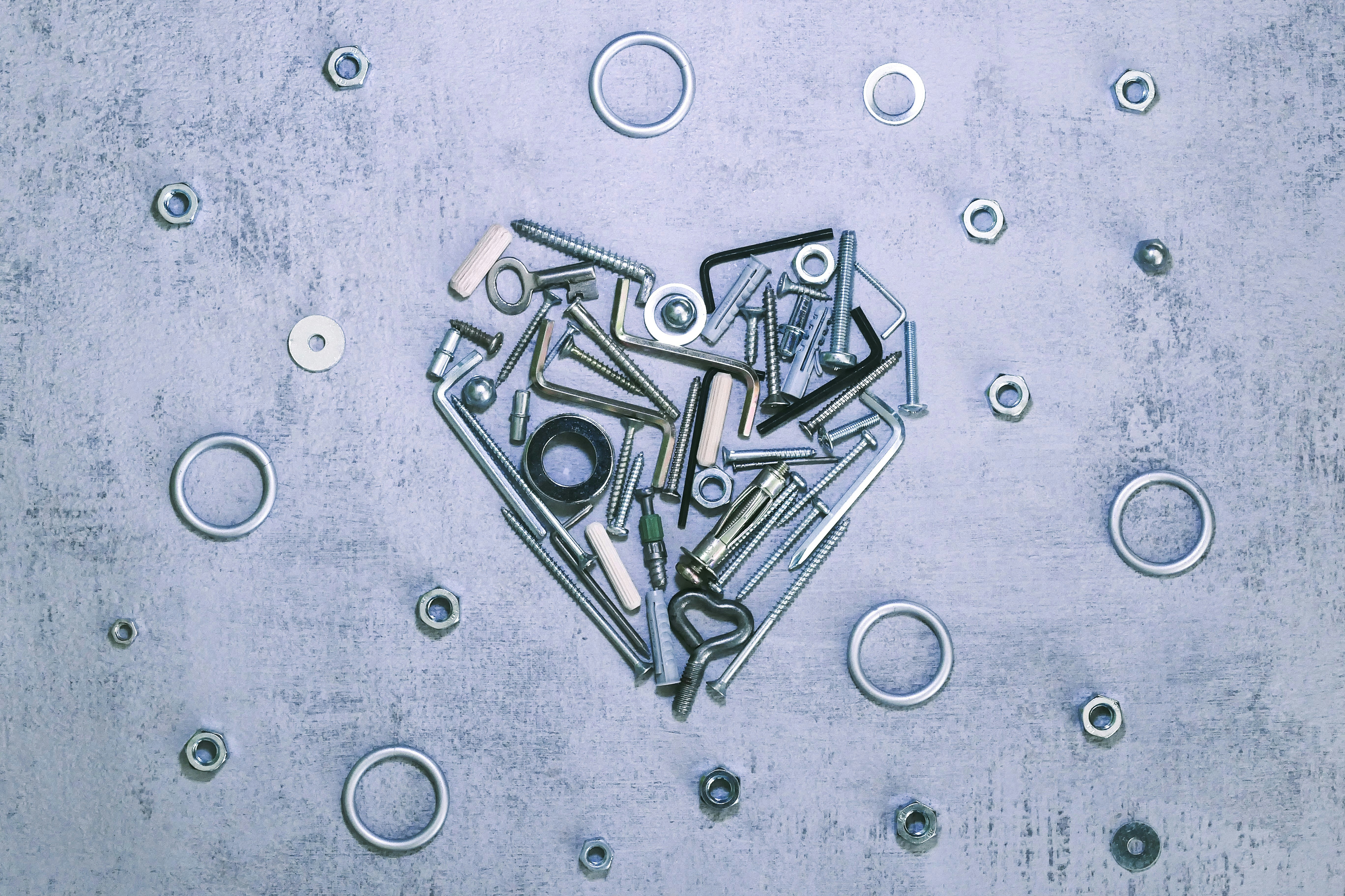 Metal hardware forms a heart on a grey background.
