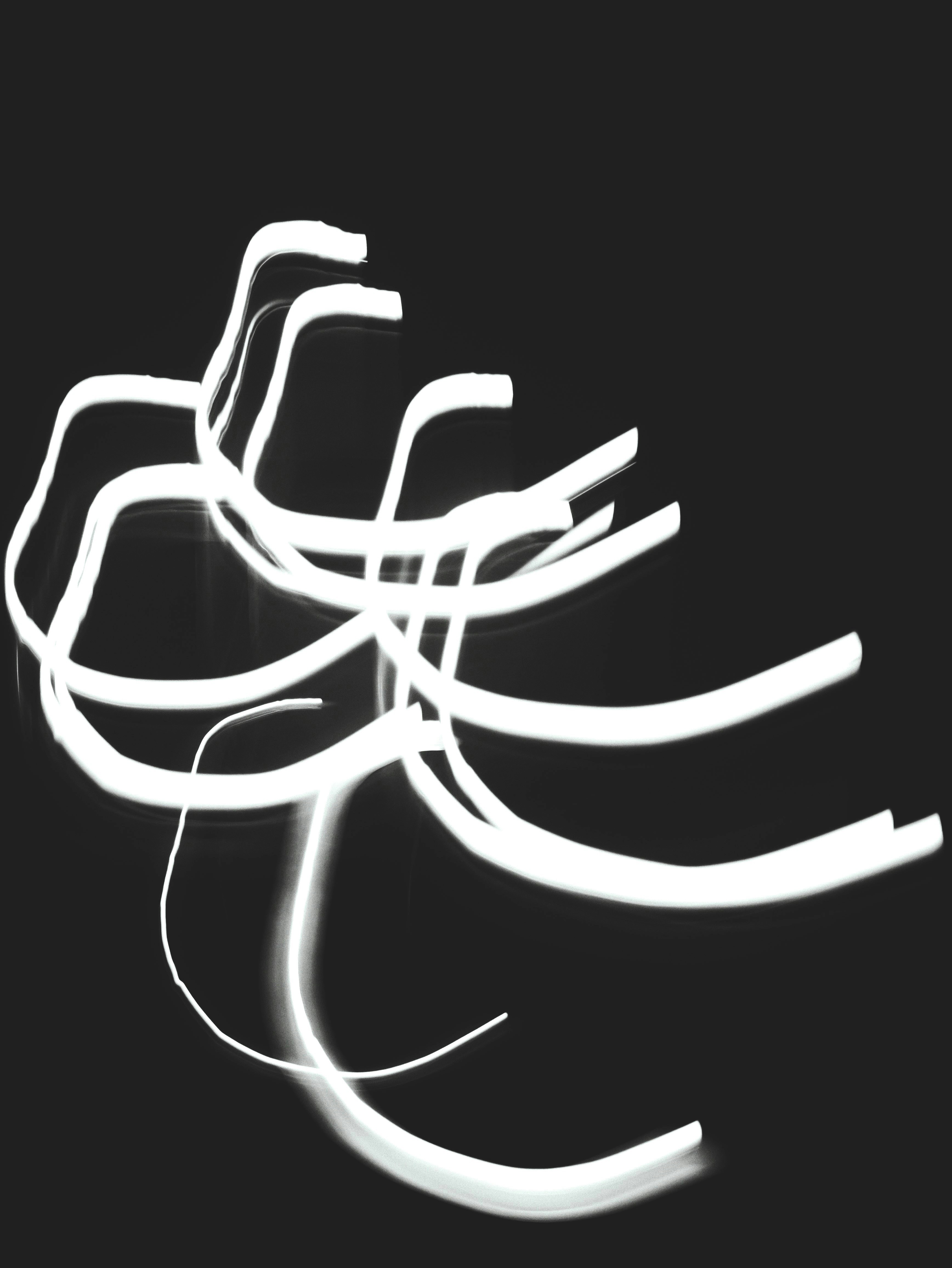White light trails create abstract patterns on a dark background.