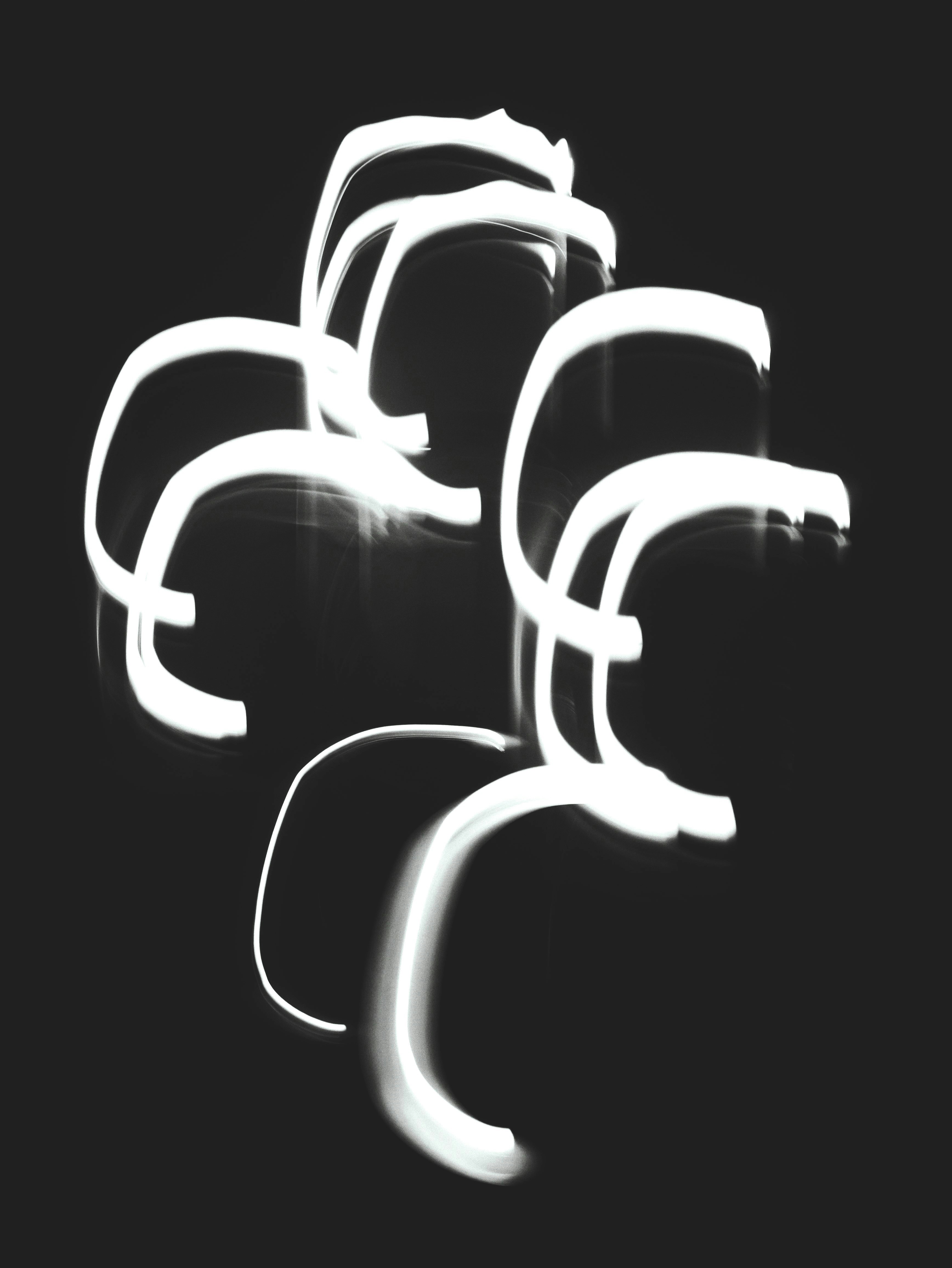 Abstract white light trails glow brightly against a dark background.