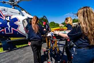 Medical personnel load a stretcher into an air ambulance helicopter.