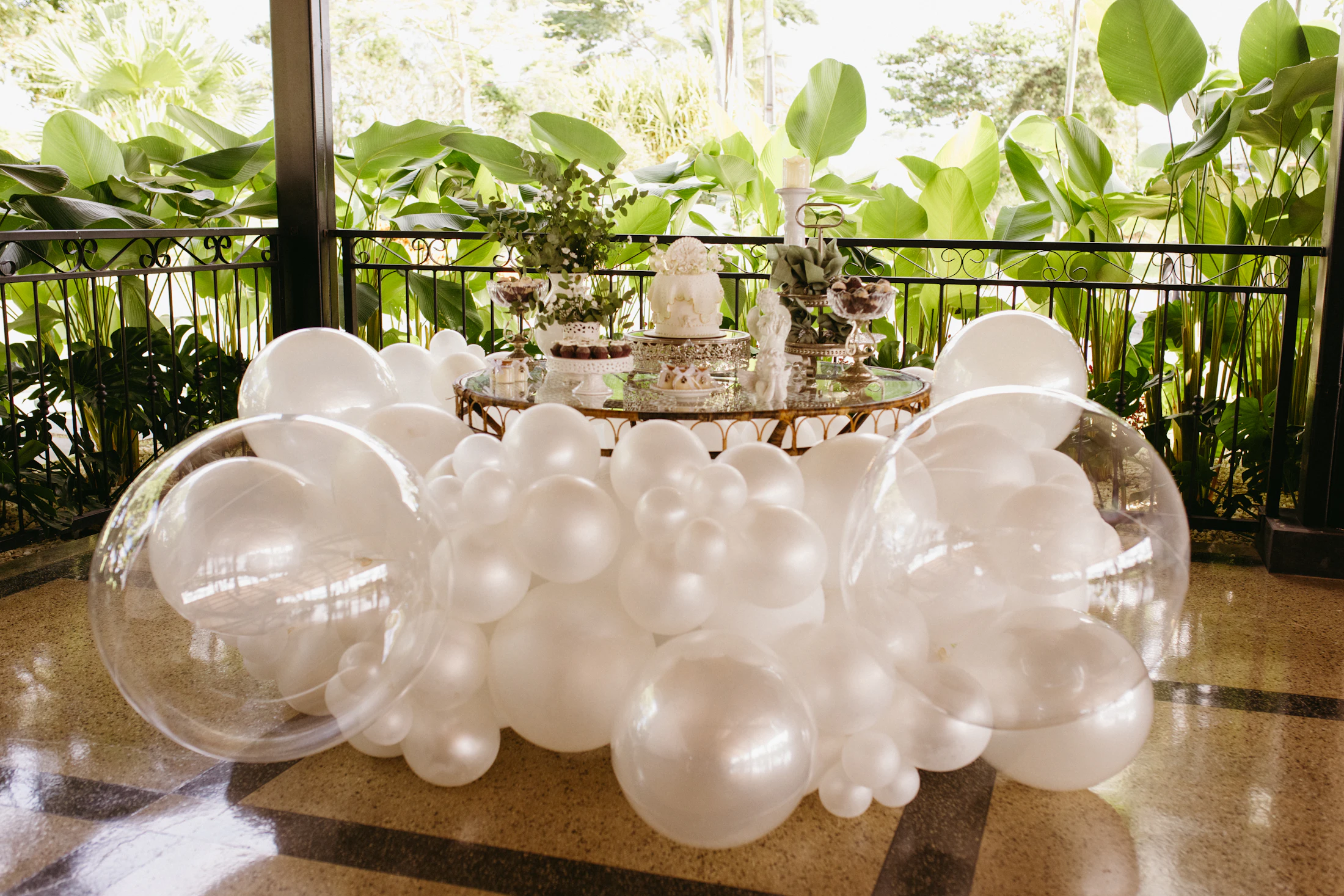 Elegant celebration table framed by white and clear balloons