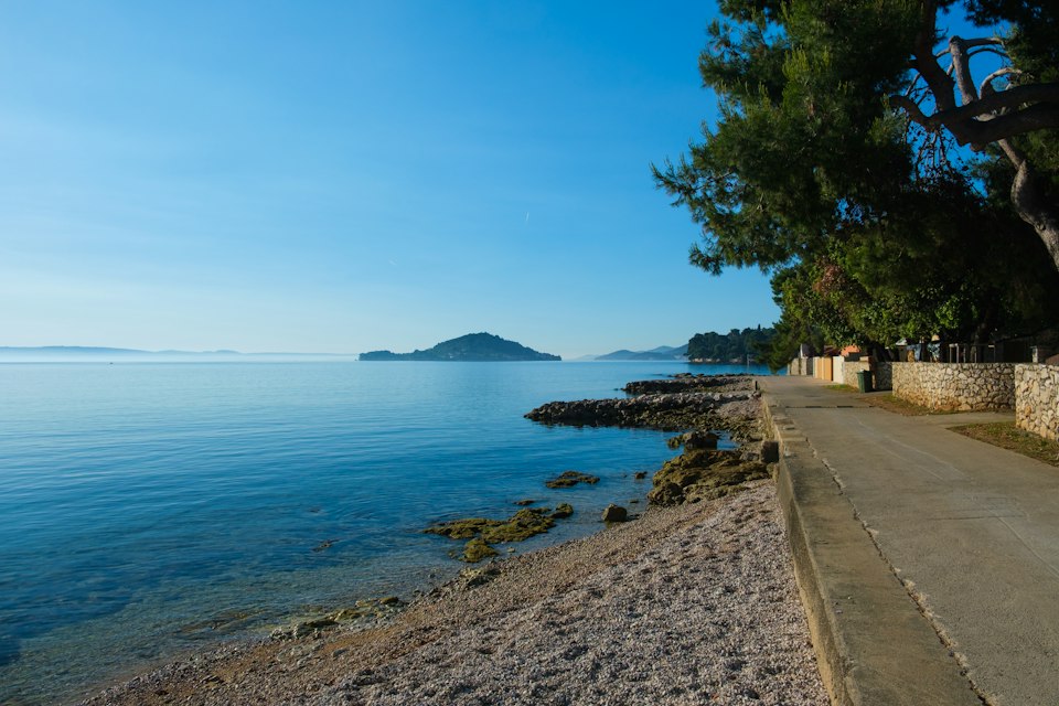 A winding Adriatic coastal road along the sea, similar to the route from Kotor to Budva