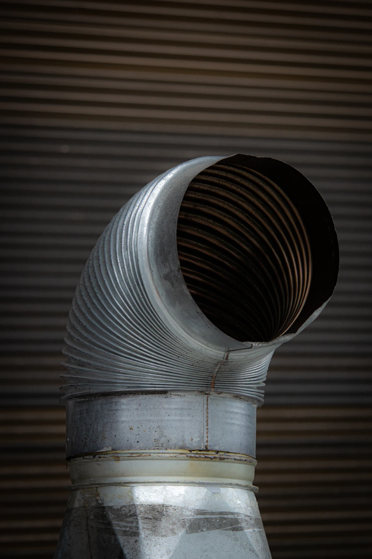 A silver flexible duct elbow