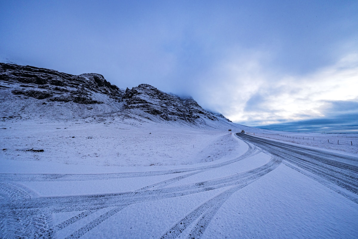 陰天下蜿蜒穿過山區的北海道冬季雪路