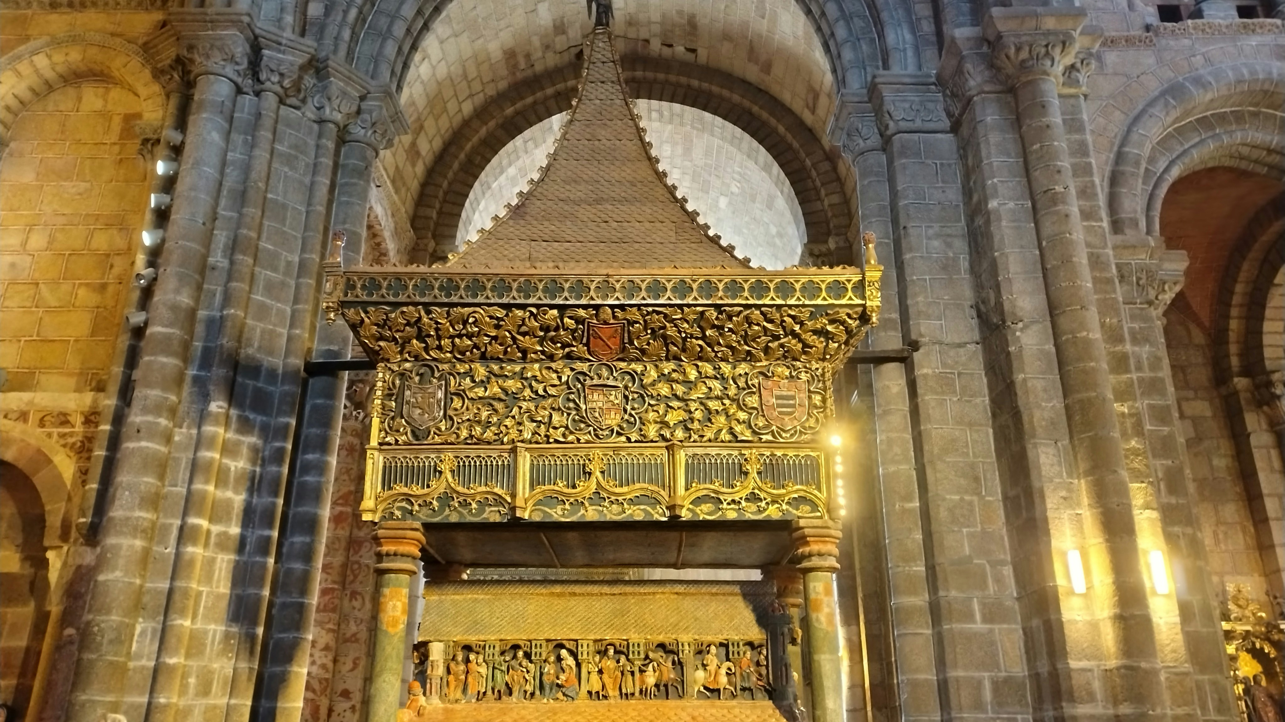 Ornate golden altar inside a historic stone cathedral.