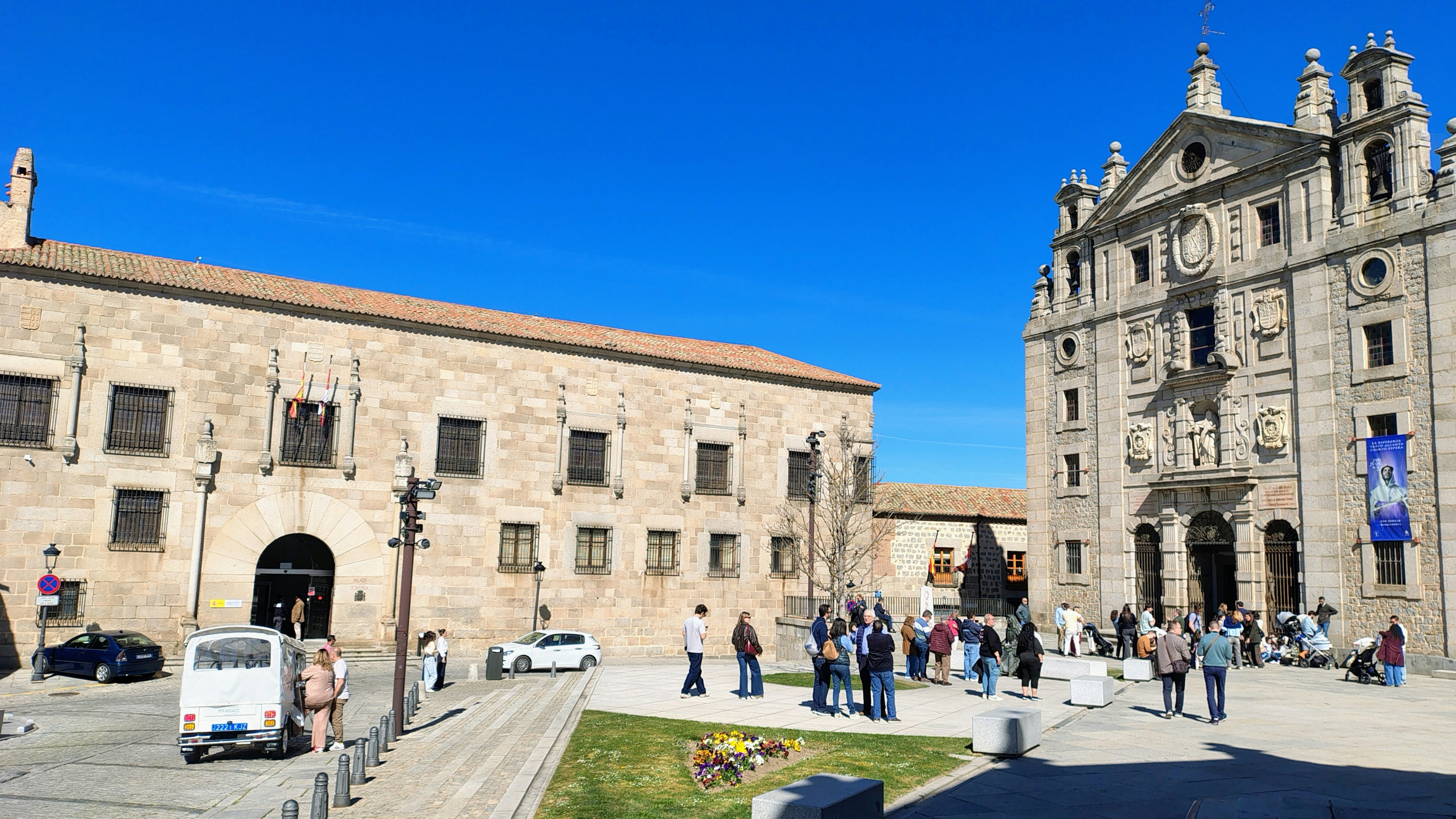 Historic church and stone building frame a bustling european sq…