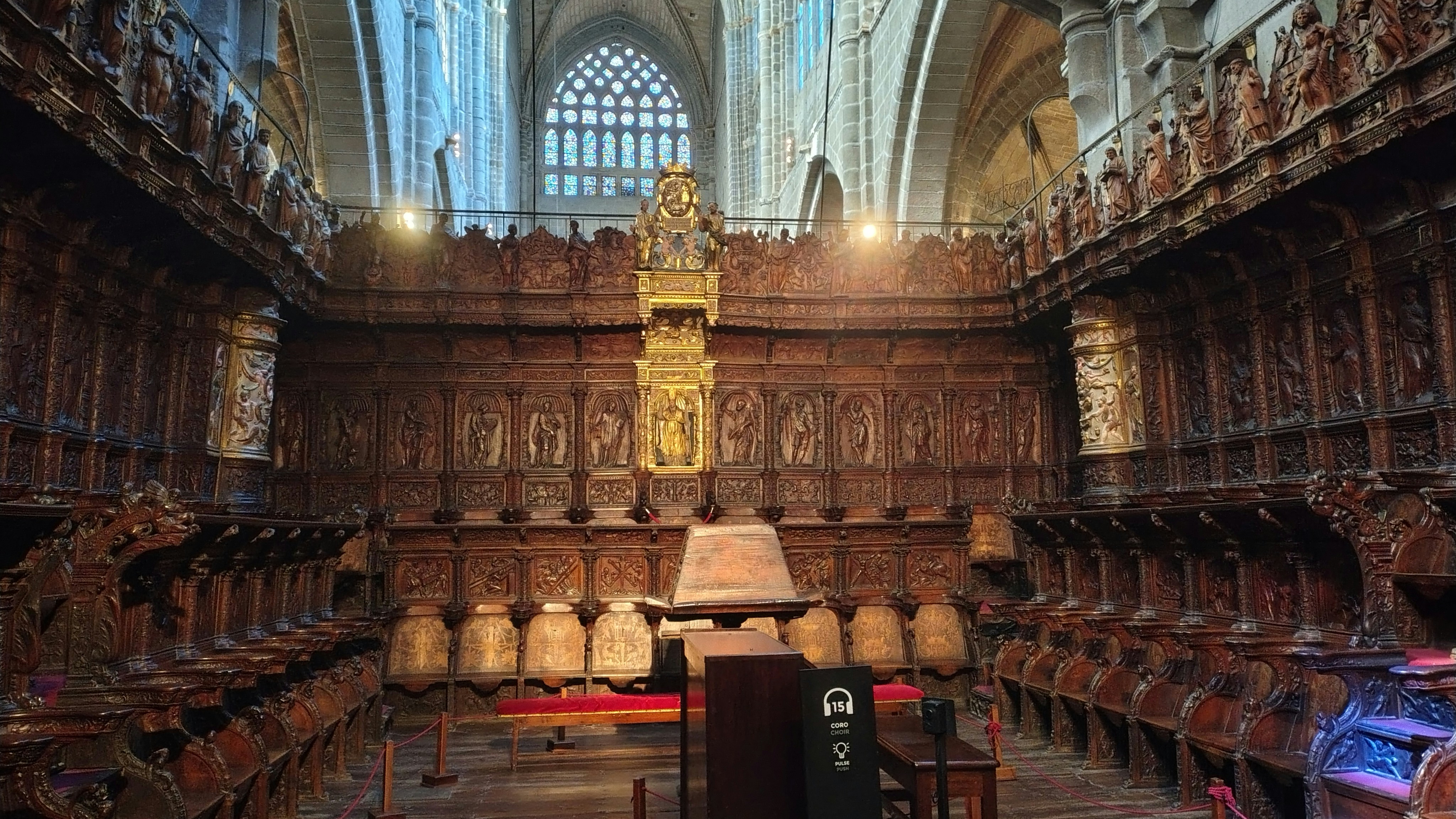 Ornate wooden choir stalls inside a grand historic cathedral.